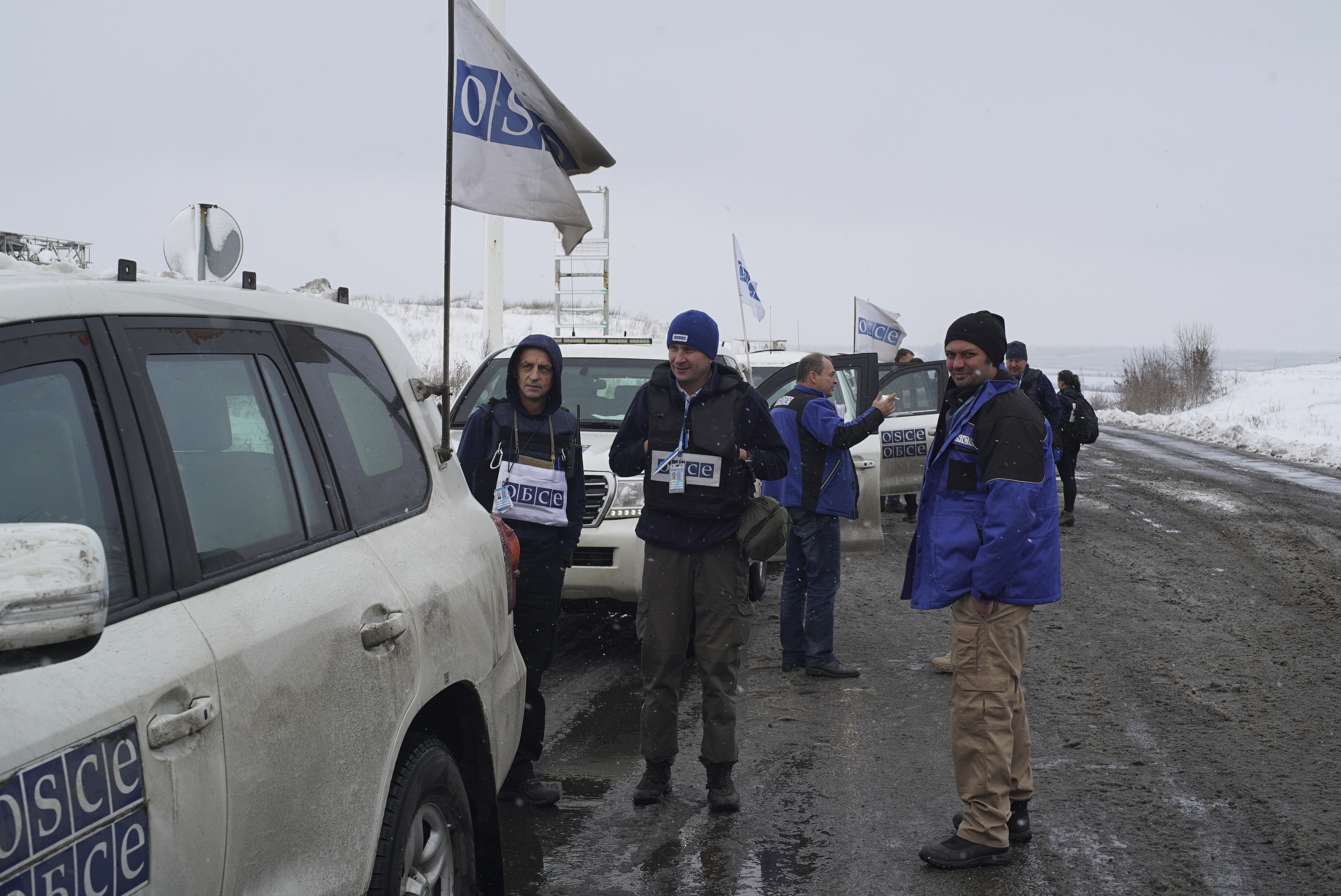 Organization for Security and Cooperation in Europe security assistant Vadym Golda, center, stands near his car during a patrol in the Donetsk region of Ukraine, Nov. 23, 2017. (AP Photo)