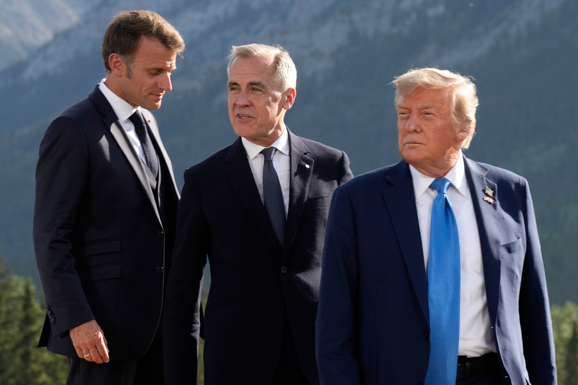 FILE - From left, French President Emmanuel Macron, Canadian Prime Minister Mark Carney and President Donald Trump arrive for the family photograph during the G7 Summit in Kananaskis, Alberta, June 16, 2025. (Adrian Wyld/The Canadian Press via AP, File)