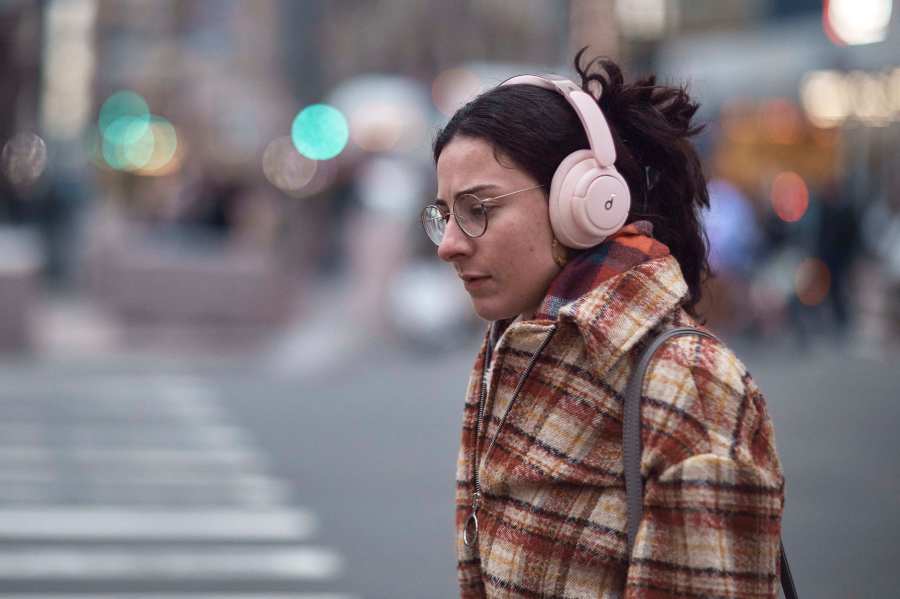 FILE - A woman walks using her headphones on Tuesday, Jan. 17, 2023, in New York. (AP Photo/Andres Kudacki, File)
