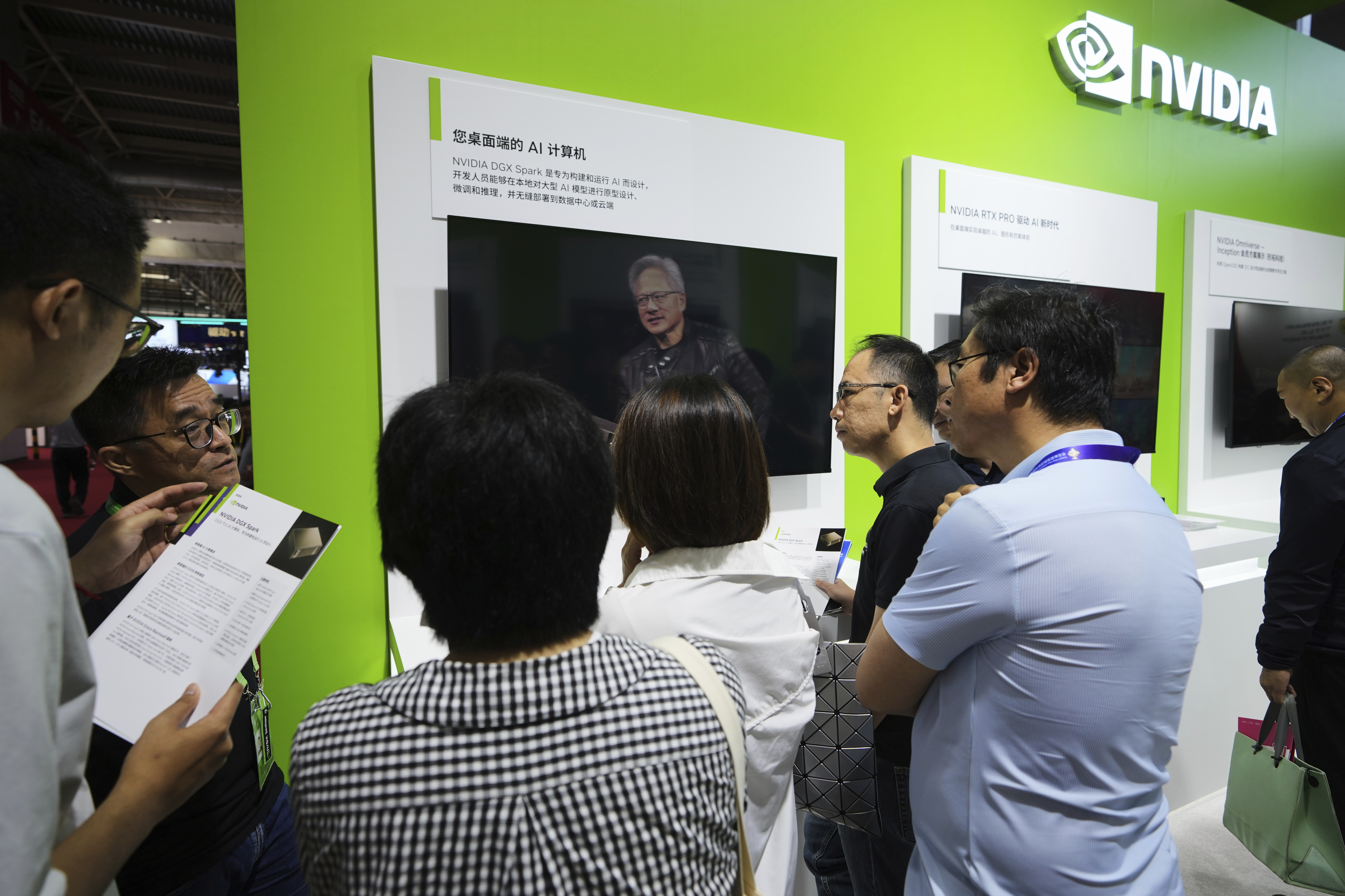 An exhibitor introduces the Nvidia DGX Spark to visitors at the Nvidia exhibition booth during the 3rd China International Supply Chain Expo at the China International Exhibition Center, in Beijing, Thursday, July 17, 2025. (AP Photo/Andy Wong)