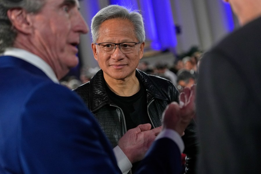 Nvidia CEO Jensen Huang talks with Interior Secretary Doug Burgum, left, before President Donald Trump speaks during an AI summit at the Andrew W. Mellon Auditorium, Wednesday, July 23, 2025, in Washington. (AP Photo/Julia Demaree Nikhinson)