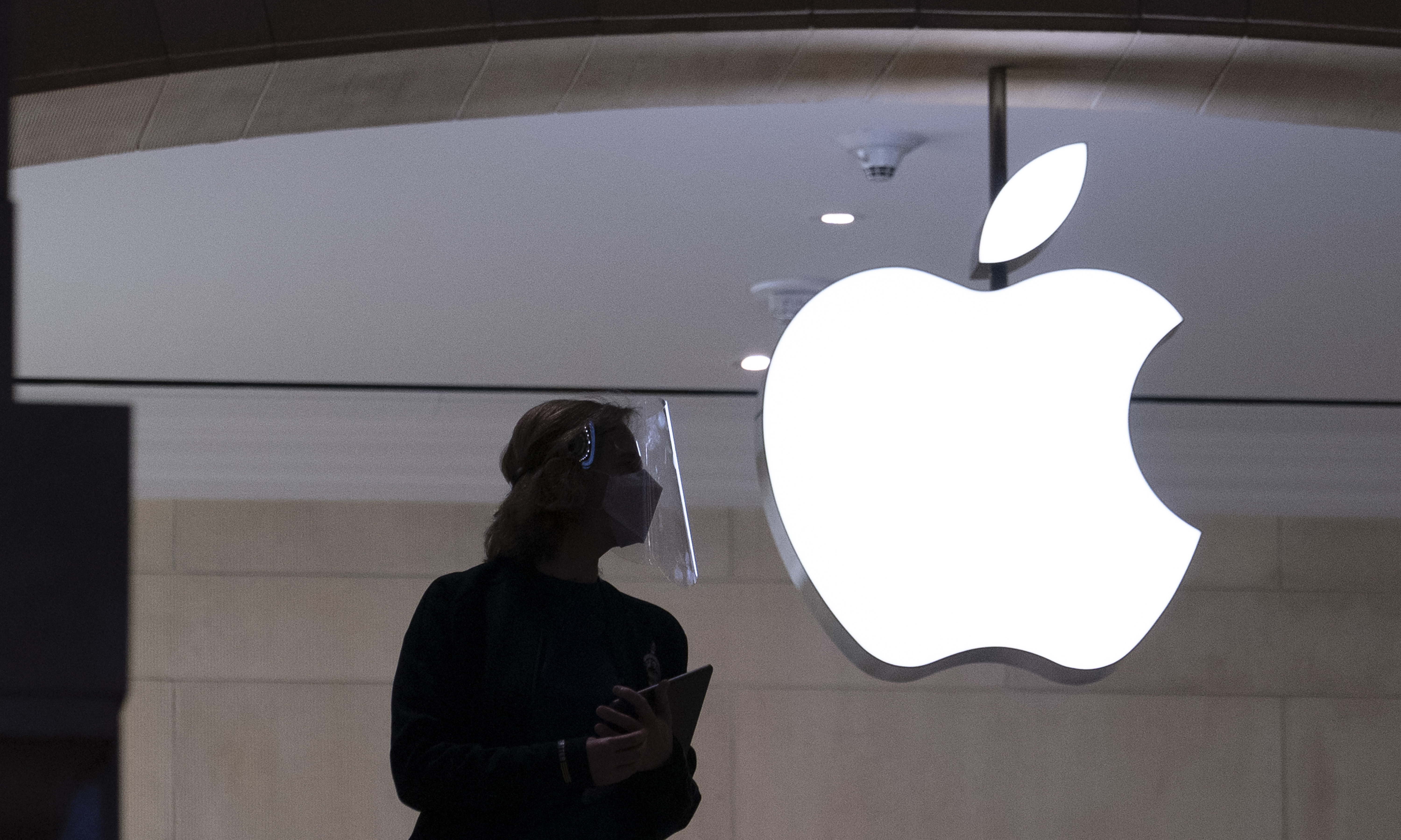 FILE - An Apple store employee stands inside the store in New York on Feb. 5, 2021. (AP Photo/Mark Lennihan, File )