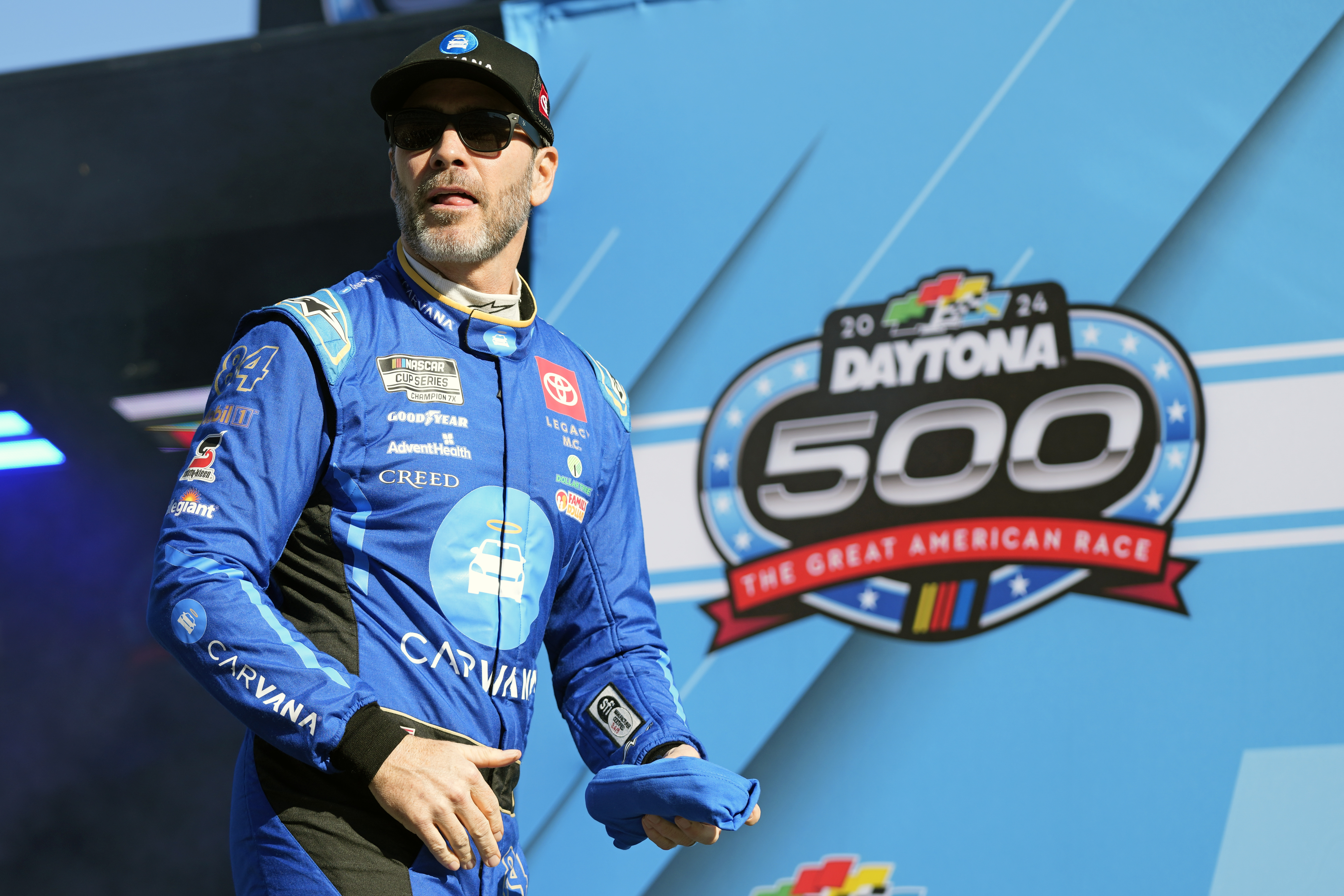 FILE - Jimmie Johnson walks across the stage during driver introductions during the NASCAR Daytona 500 auto race at Daytona International Speedway, Monday, Feb. 19, 2024, in Daytona Beach, Fla. (AP Photo/John Raoux, File)