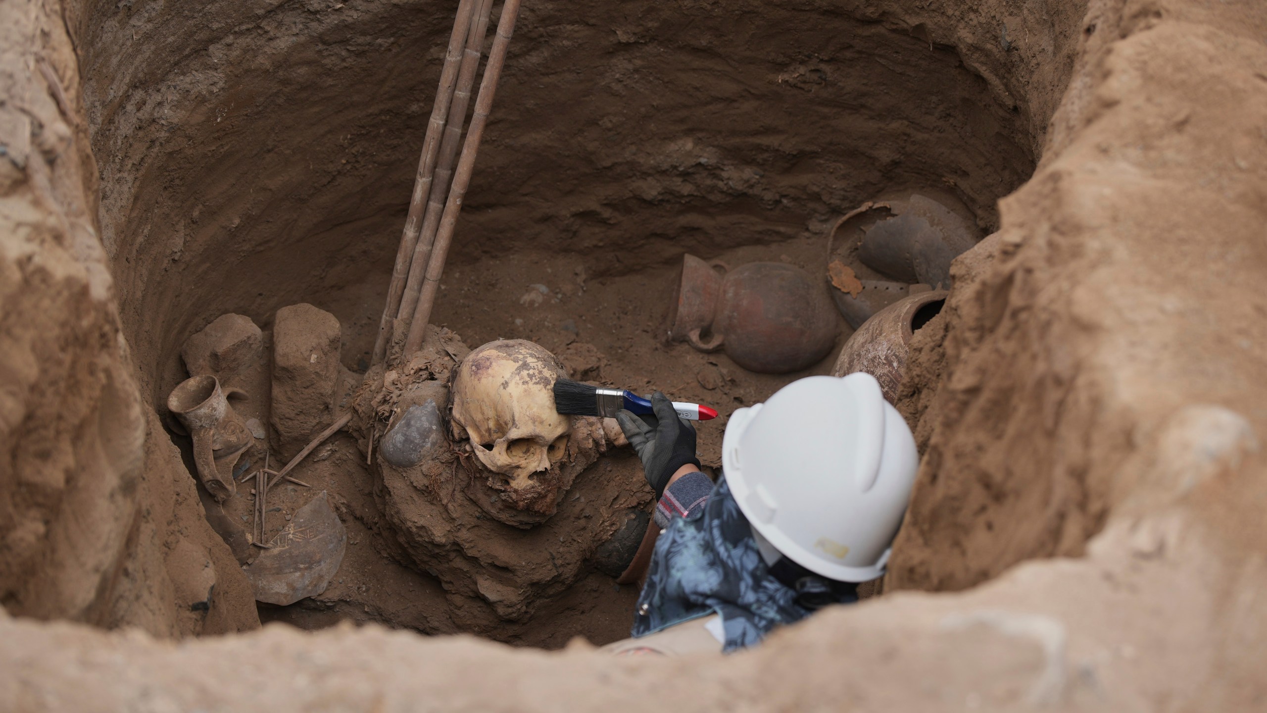 Archaeologist Jose Aliaga works at the site where city workers discovered ancient remains, from the pre-Inca Chancay culture, and artifacts as workers were digging a natural gas line for the company Calidda in the district of Puente Piedra on the outskirts of Lima, Peru, Thursday, July 31, 2025. (AP Photo/Guadalupe Pardo)