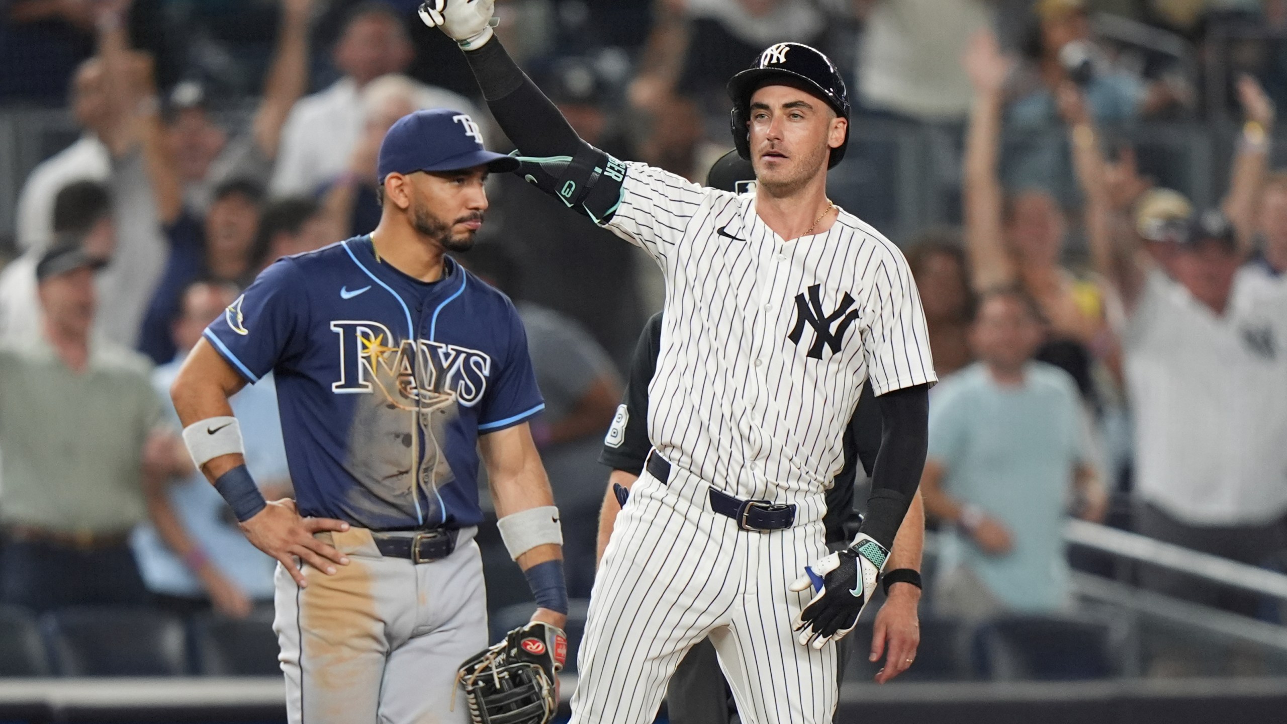 Tampa Bay Rays shortstop José Caballero watches as New York Yankees' Cody Bellinger gestures to teammates after hitting an RBI triple during the 10th inning of a baseball game Wednesday, July 30, 2025, in New York. (AP Photo/Frank Franklin II)