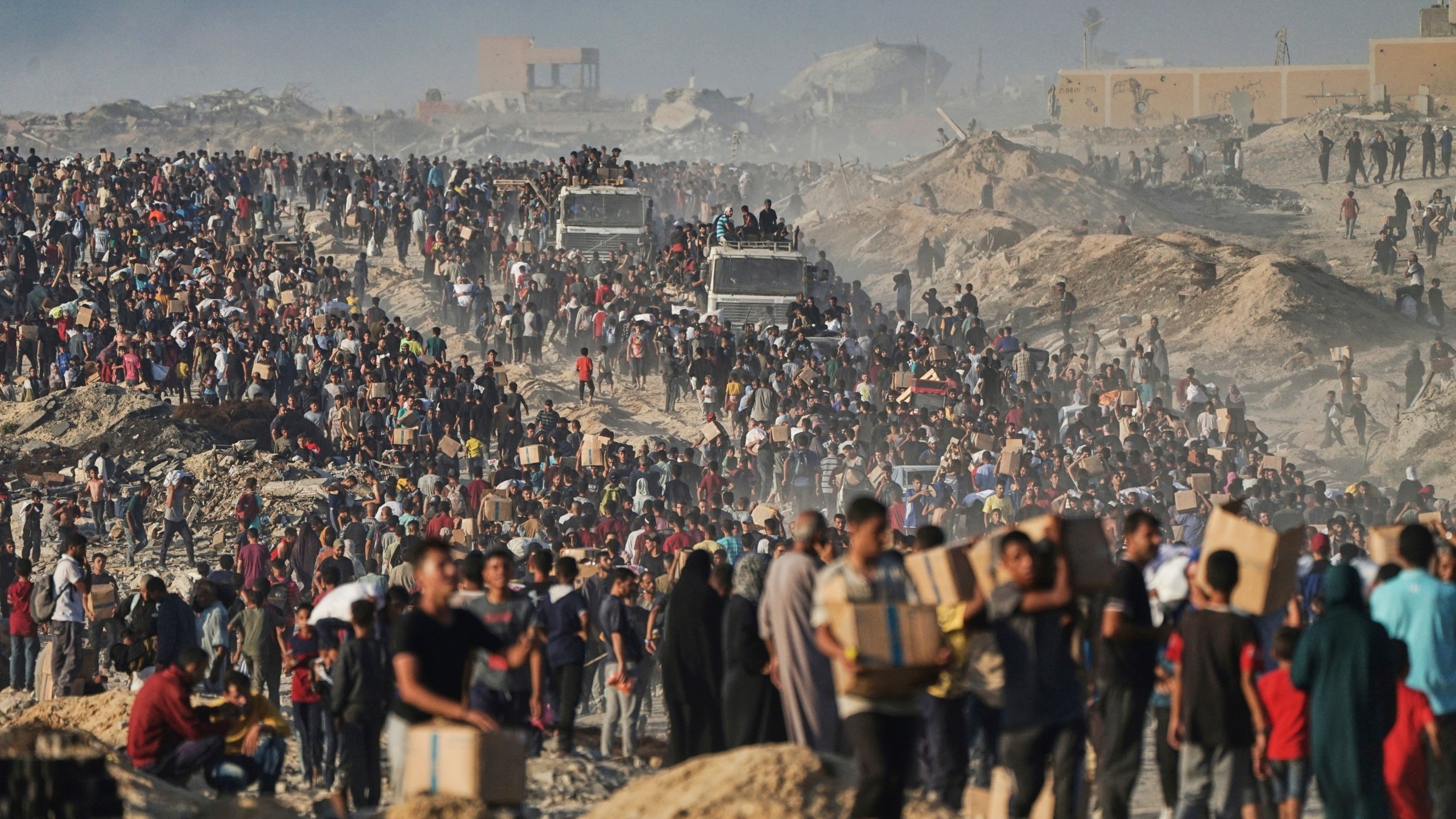 FILE - Palestinians carry humanitarian aid from a World Food Program convoy that was heading to Gaza City, June 16, 2025. (AP Photo/Jehad Alshrafi, File)