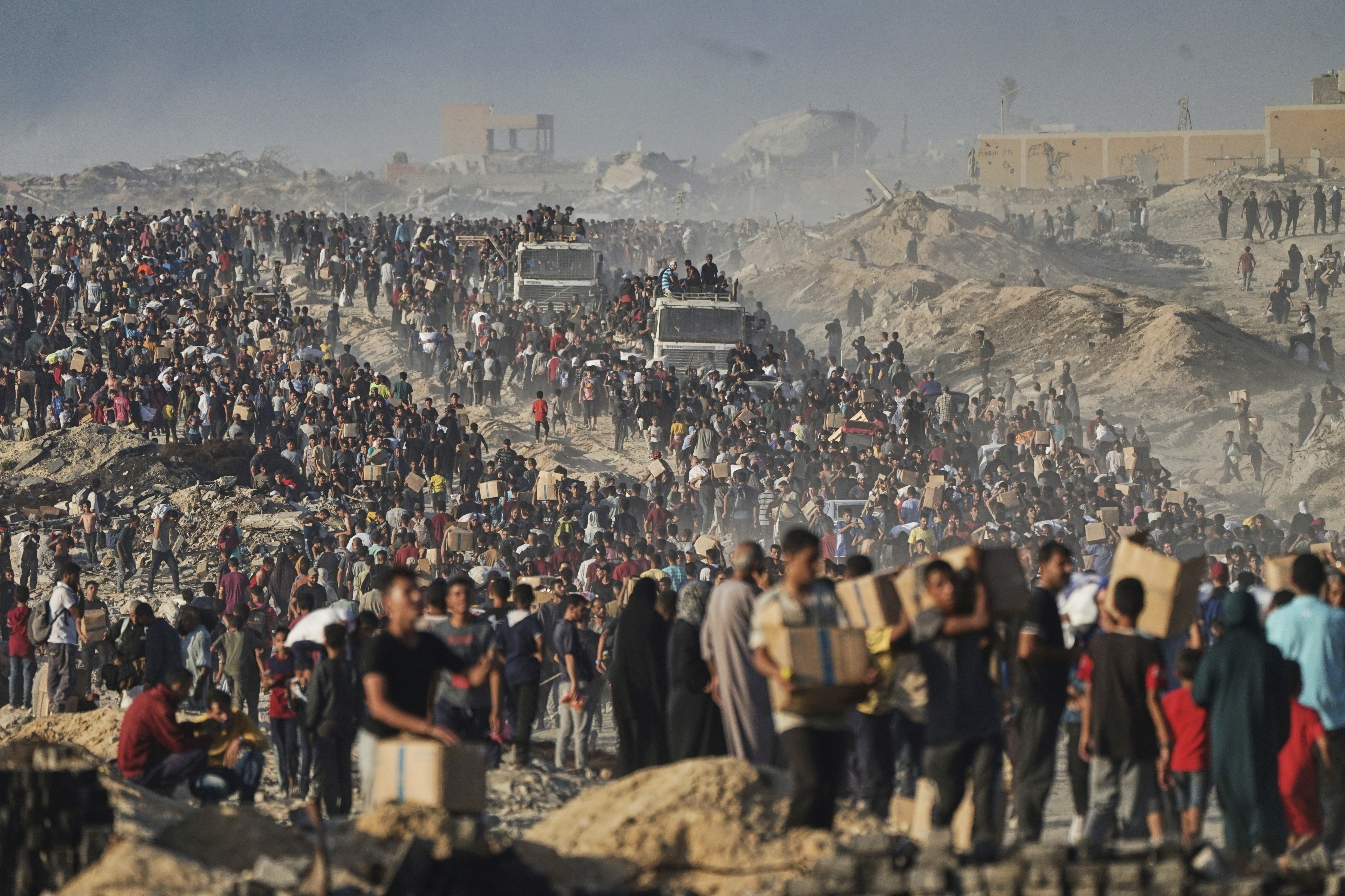 FILE - Palestinians carry humanitarian aid from a World Food Program convoy that was heading to Gaza City, June 16, 2025. (AP Photo/Jehad Alshrafi, File)