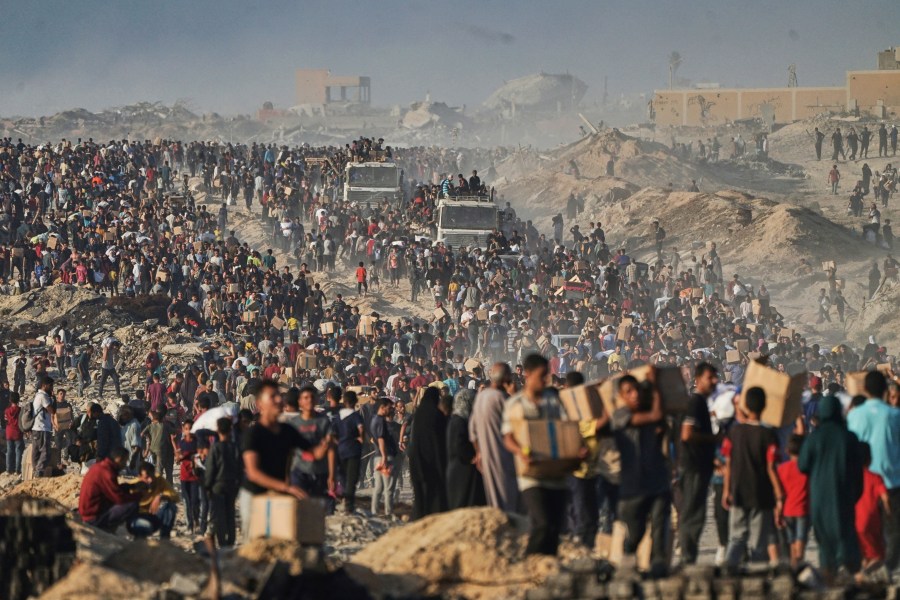 FILE - Palestinians carry humanitarian aid from a World Food Program convoy that was heading to Gaza City, June 16, 2025. (AP Photo/Jehad Alshrafi, File)