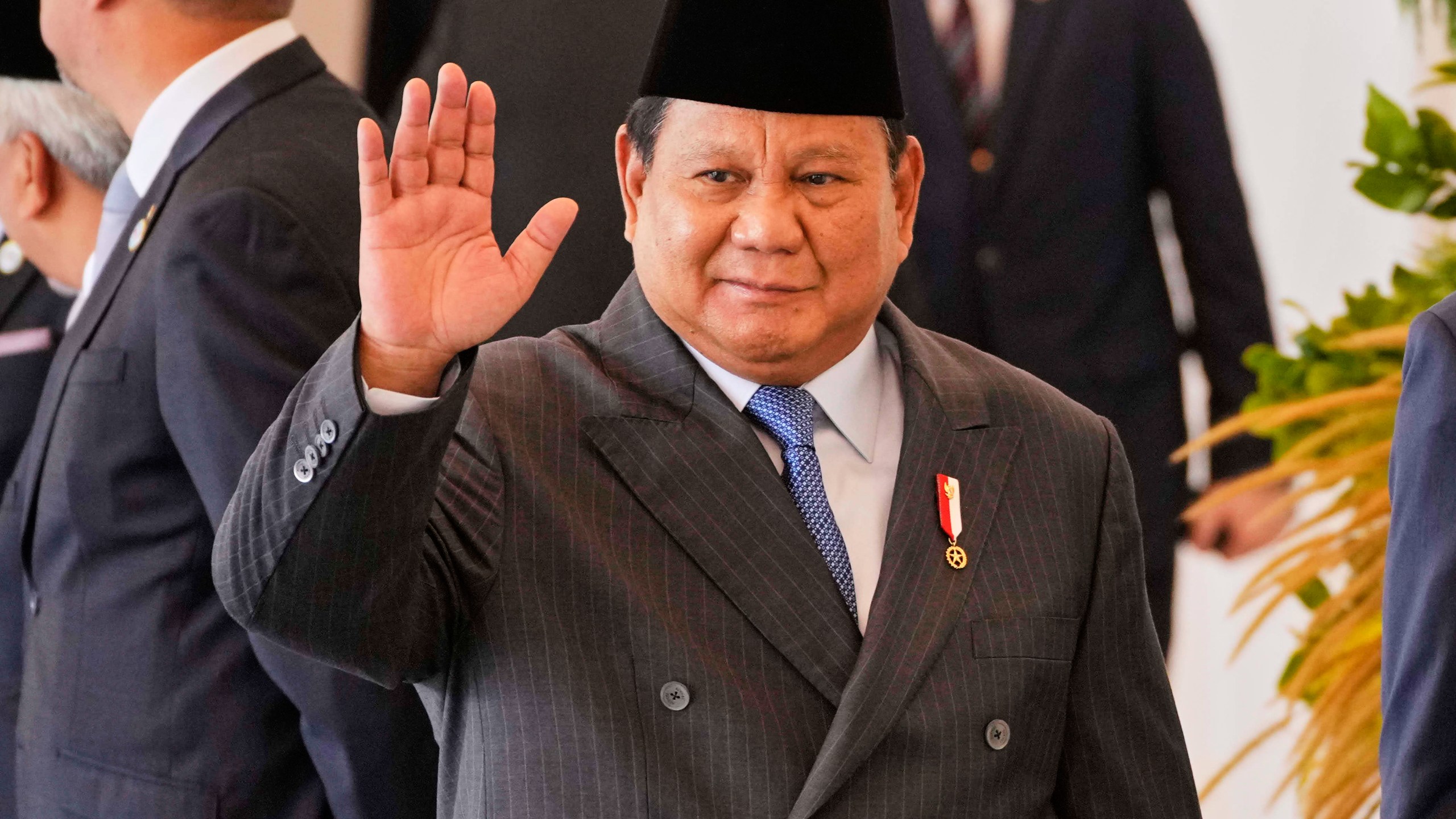 Indonesian President Prabowo Subianto waves to journalists at Merdeka Palace in Jakarta, Indonesia, Tuesday, July 29, 2025. (AP Photo/Achmad Ibrahim)