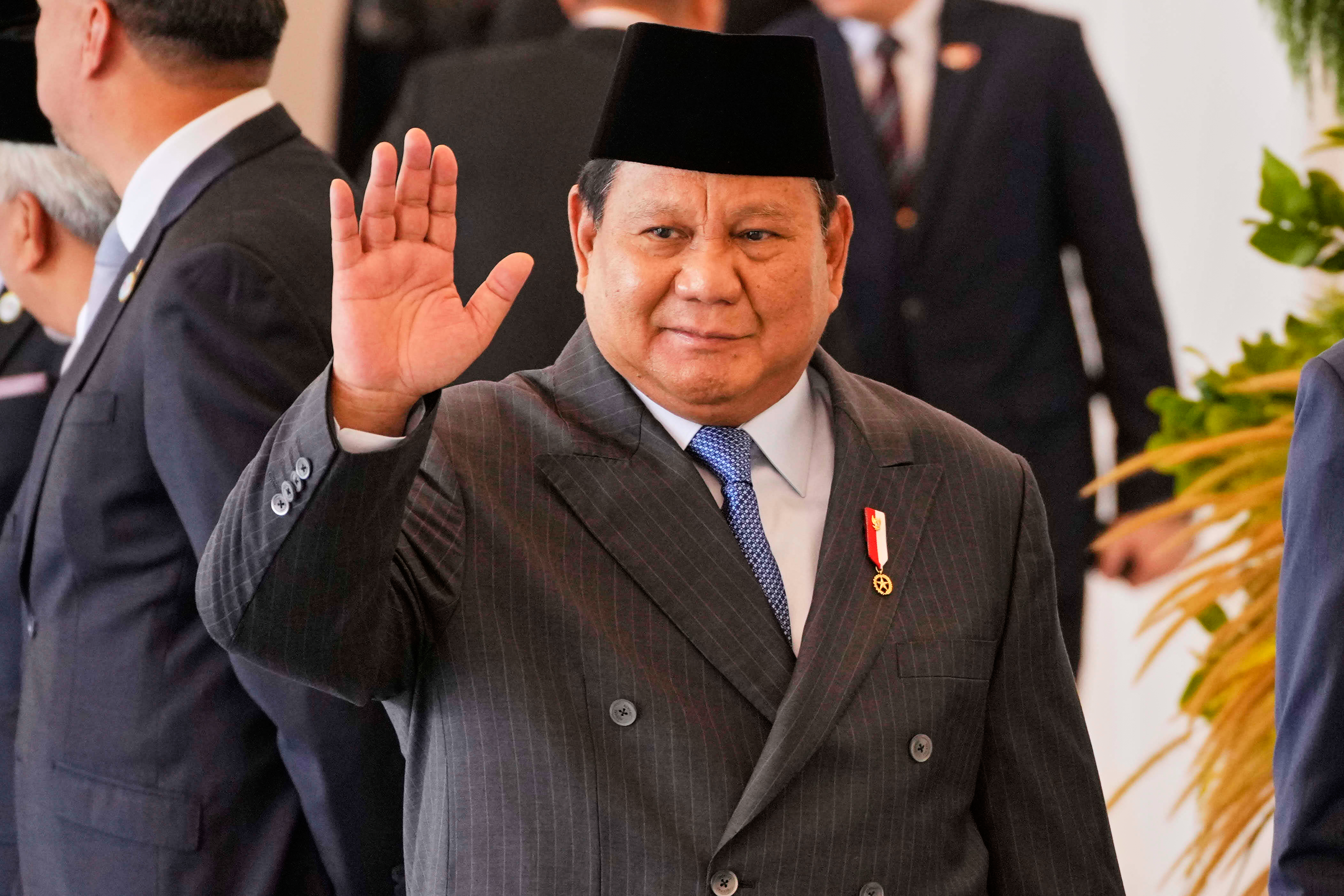 Indonesian President Prabowo Subianto waves to journalists at Merdeka Palace in Jakarta, Indonesia, Tuesday, July 29, 2025. (AP Photo/Achmad Ibrahim)