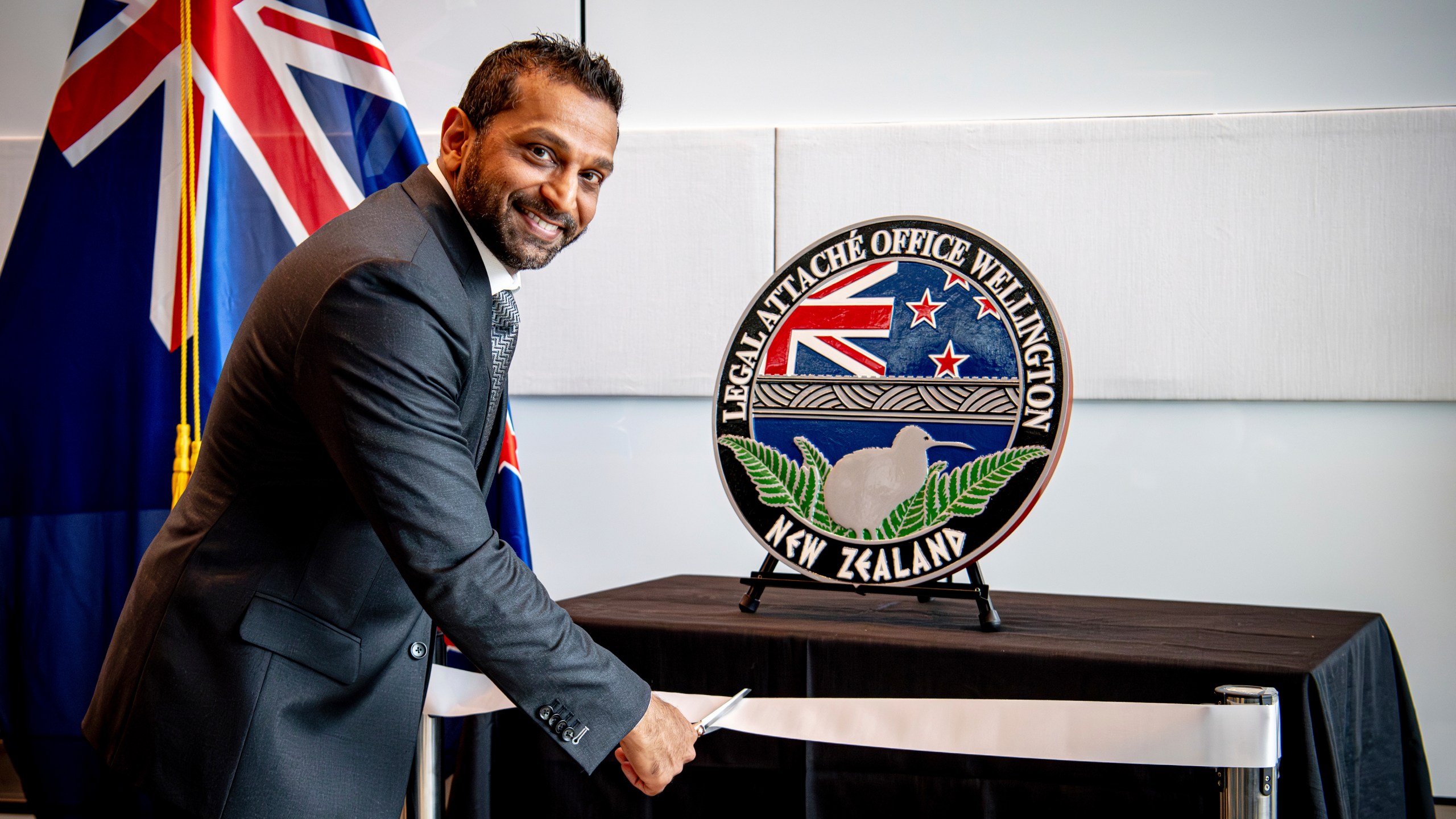 In this photo released by the US Embassy in Wellington, New Zealand, FBI Director Kash Patel cuts the ribbon at the official opening of the FBI office in Wellington, New Zealand, Thursday, July 31, 2025. (Ola Thorsen/US Embassy via AP)