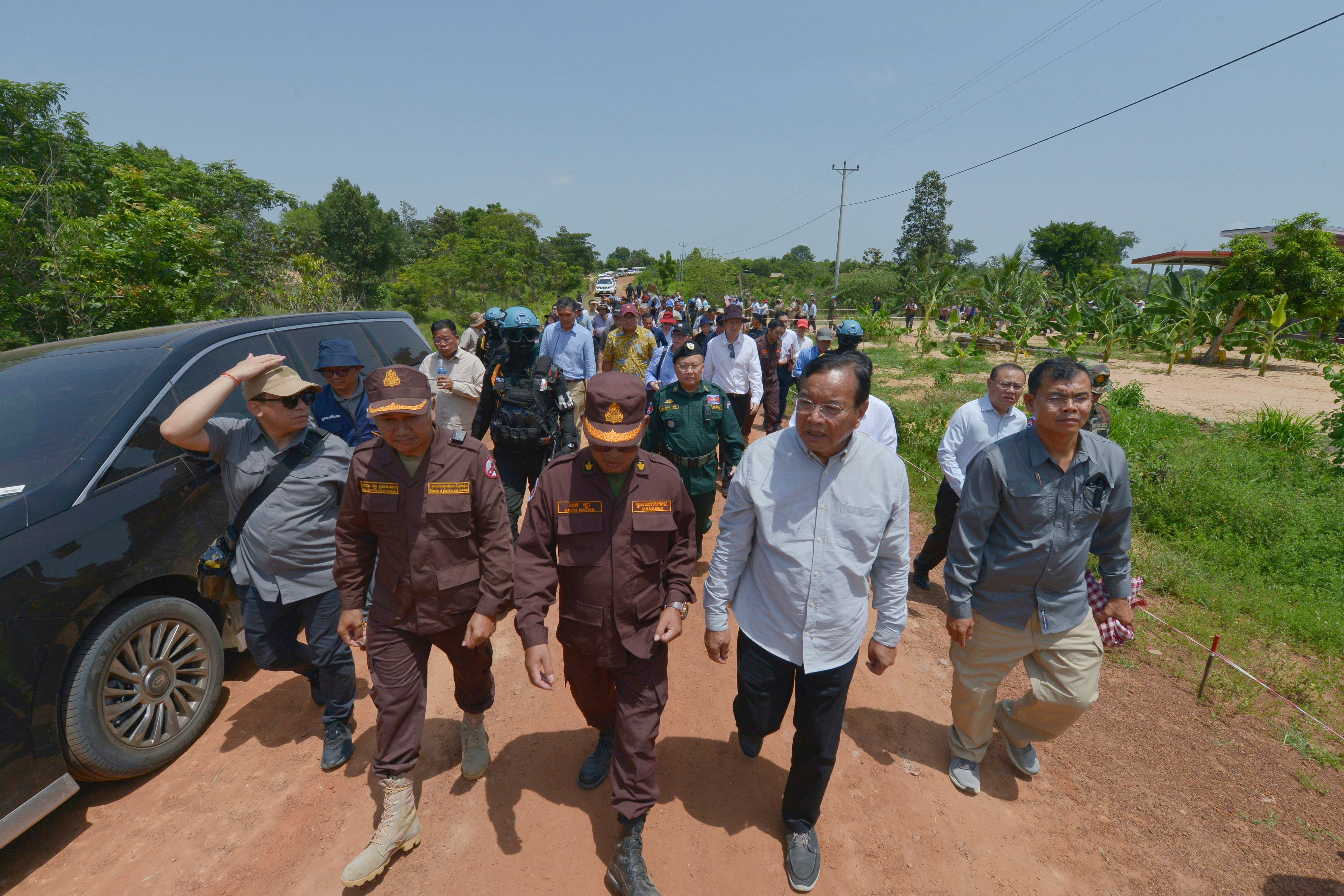 In this photo released by Agence Kampuchea Press (AKP), Cambodian Foreign Minister Prak Sokhonn, second from right, leads diplomats during a border visit to inspect dameges from the recent clash in Oddar Meanchey province, Cambodia, Friday, Aug. 1, 2025. (AKP via AP)