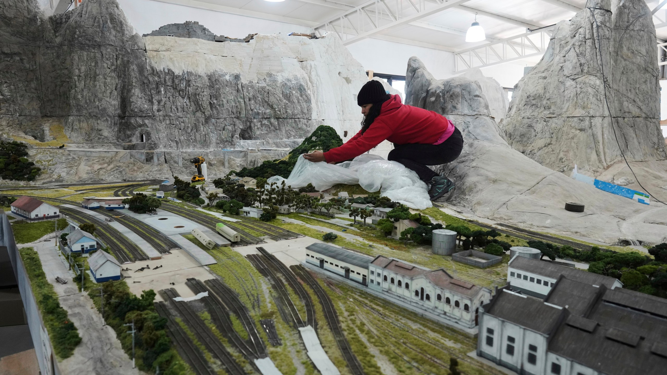 Workers in Pilar, Argentina, Wednesday, June 25, 2025, construct a miniature version of Mairinque, Brazil. (AP Photo/Natacha Pisarenko)