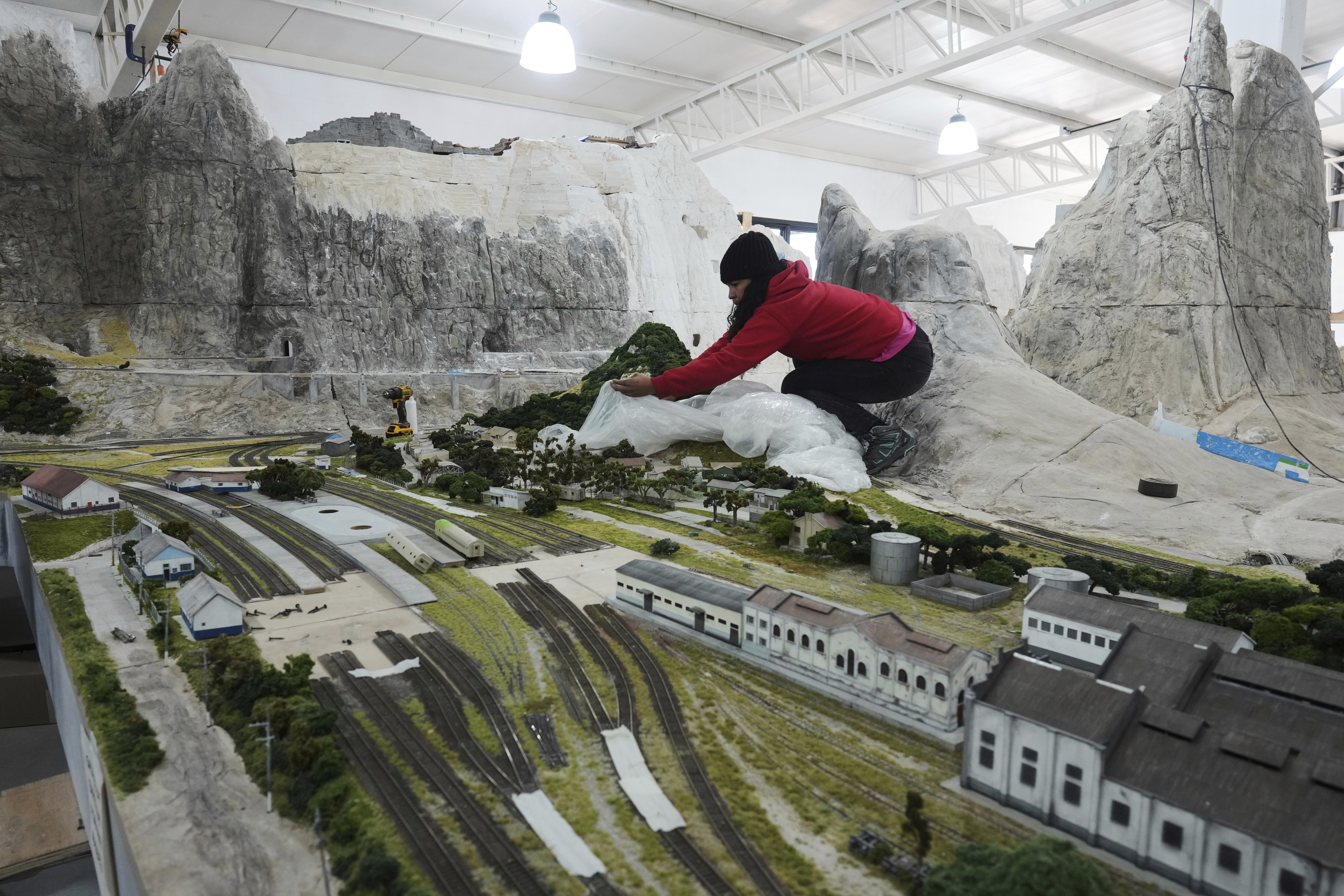 Workers in Pilar, Argentina, Wednesday, June 25, 2025, construct a miniature version of Mairinque, Brazil. (AP Photo/Natacha Pisarenko)