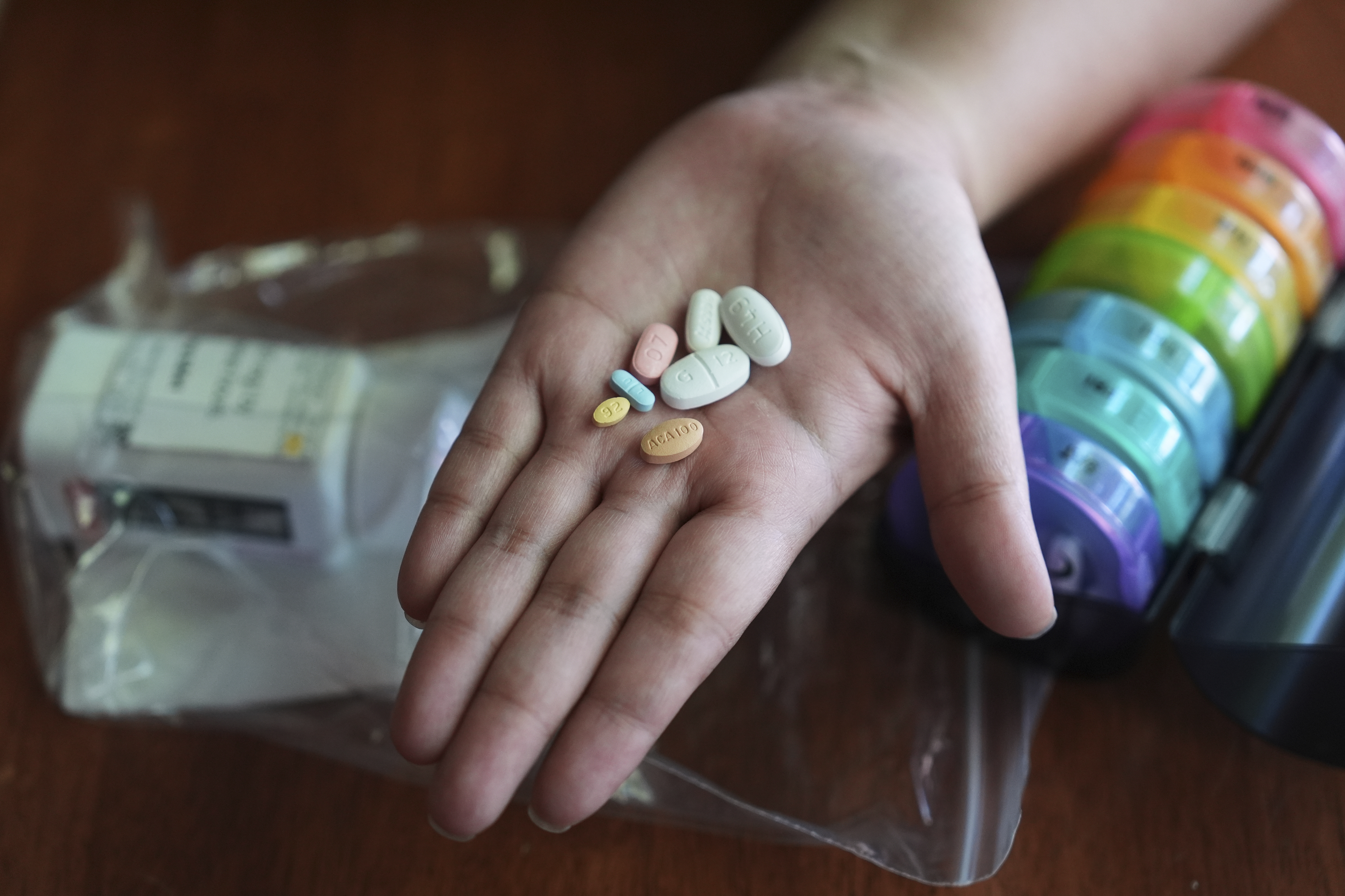 Amanda Schlesier holds her prescription medication, including a chemotherapy pill, Calquence, foreground, in Farmington Hills, Mich., Wednesday, July 23, 2025. (AP Photo/Paul Sancya)