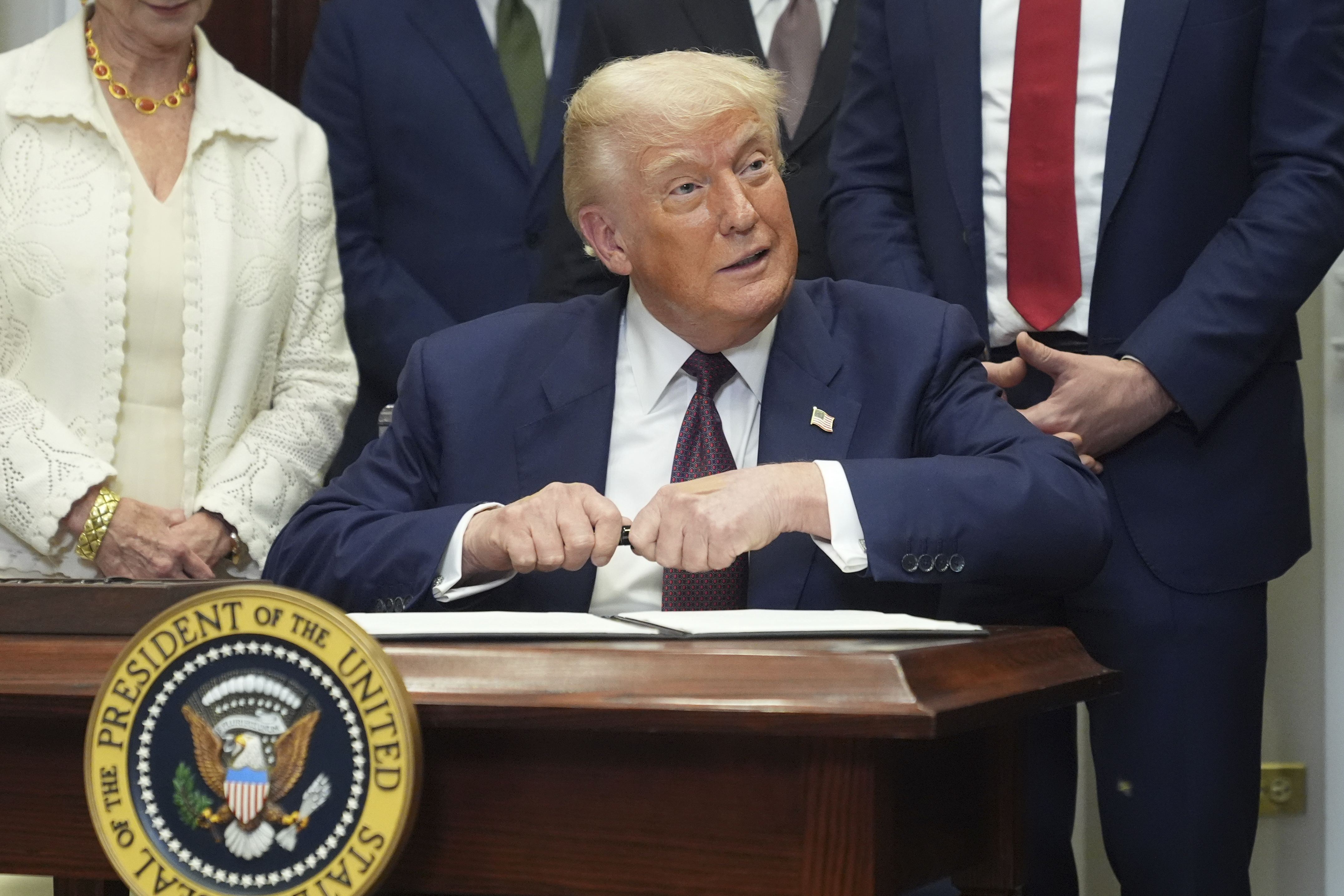 President Donald Trump signs an executive order restarting the Presidential Fitness Test in public schools, Thursday, July 31, 2025, in the Roosevelt Room of the White House in Washington. (AP Photo/Jacquelyn Martin)