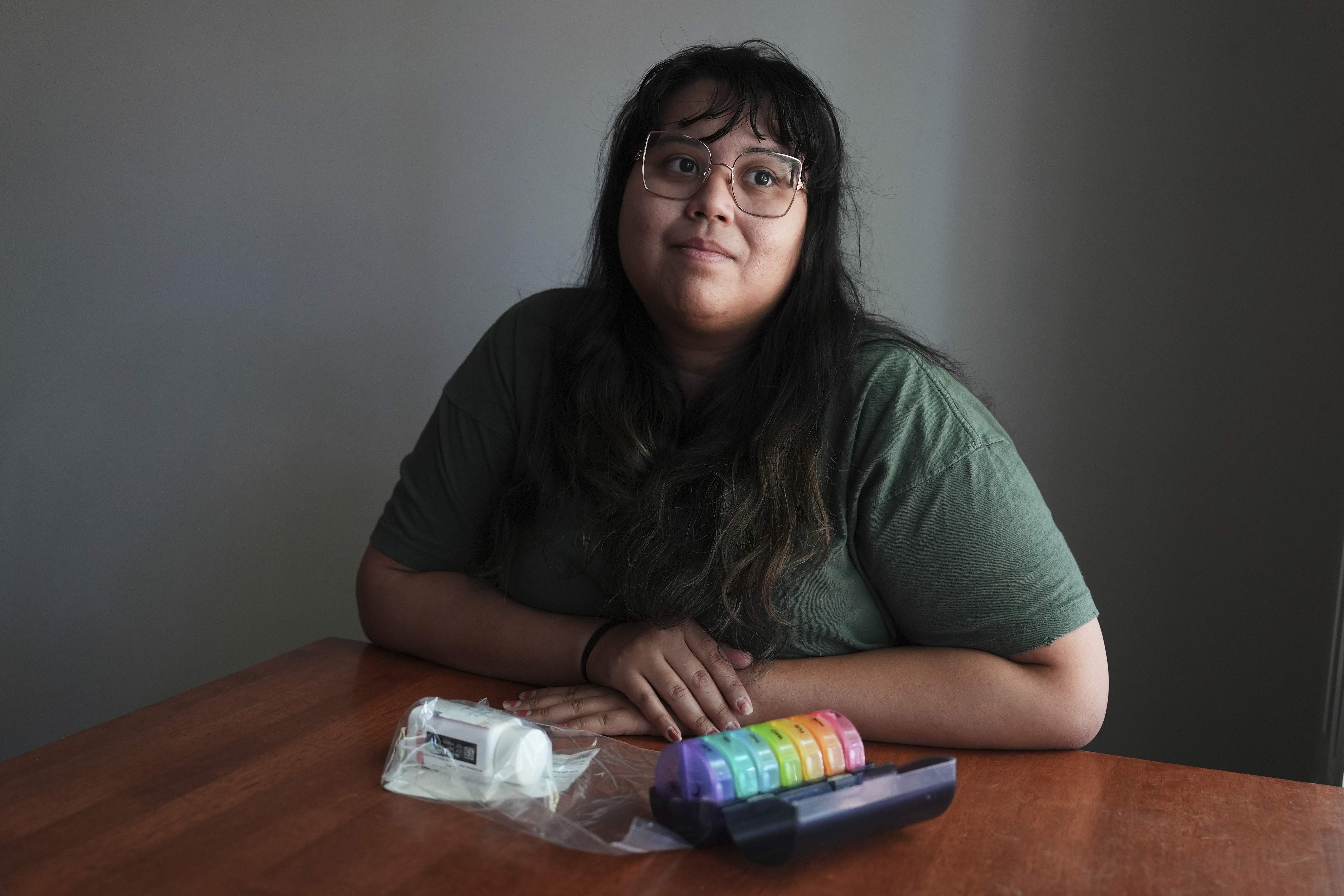 Amanda Schlesier sits for a portrait with her prescriptions, including her chemotherapy pill, Calquence, in Farmington Hills, Mich., Wednesday, July 23, 2025. (AP Photo/Paul Sancya)