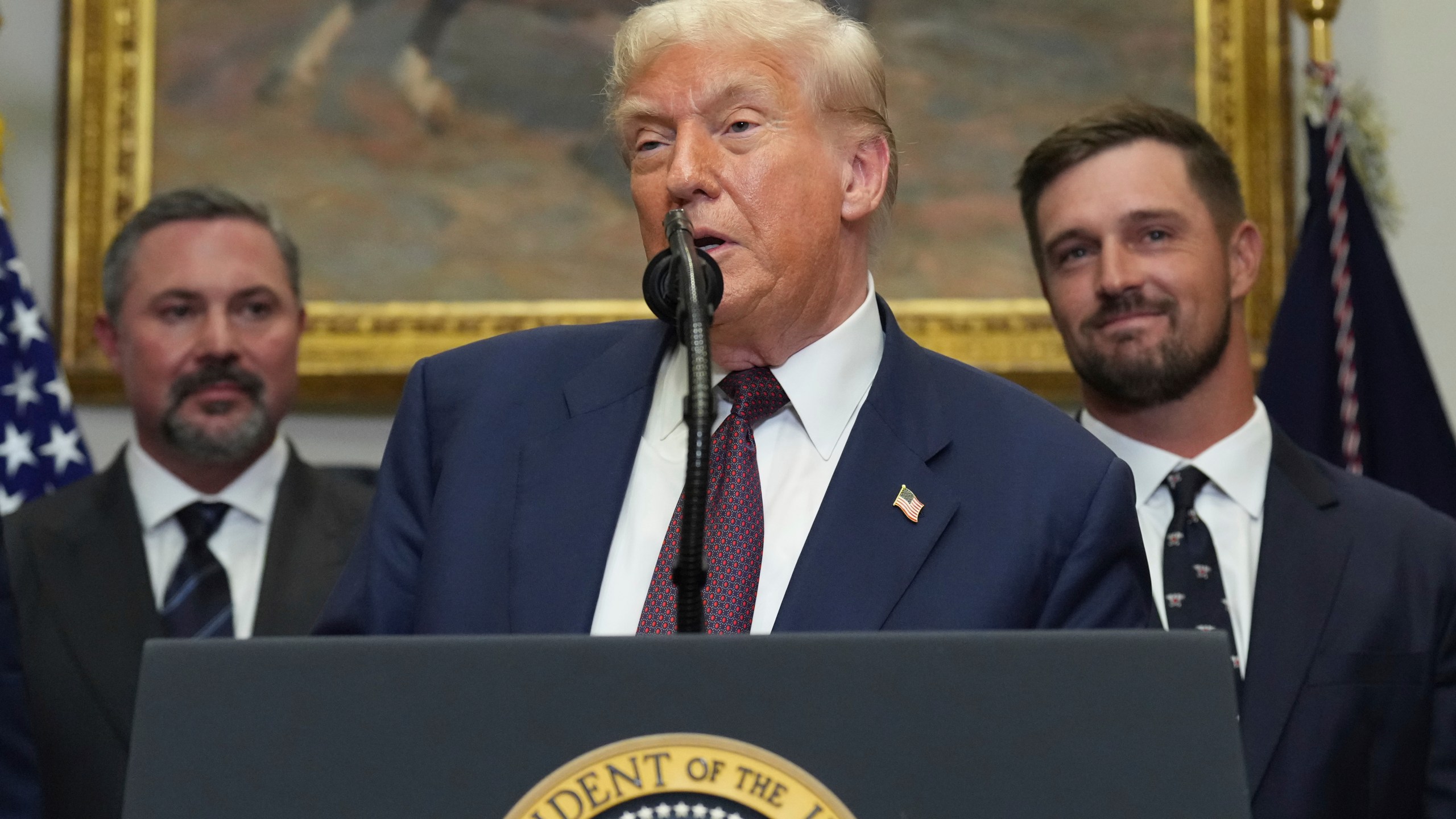 President Donald Trump speaks as Cody Campbell, left, and professional golfer Bryson DeChambeau listen during an event for the signing of an executive order restarting the Presidential Fitness Test in public schools, Thursday, July 31, 2025, in the Roosevelt Room of the White House in Washington. (AP Photo/Jacquelyn Martin)