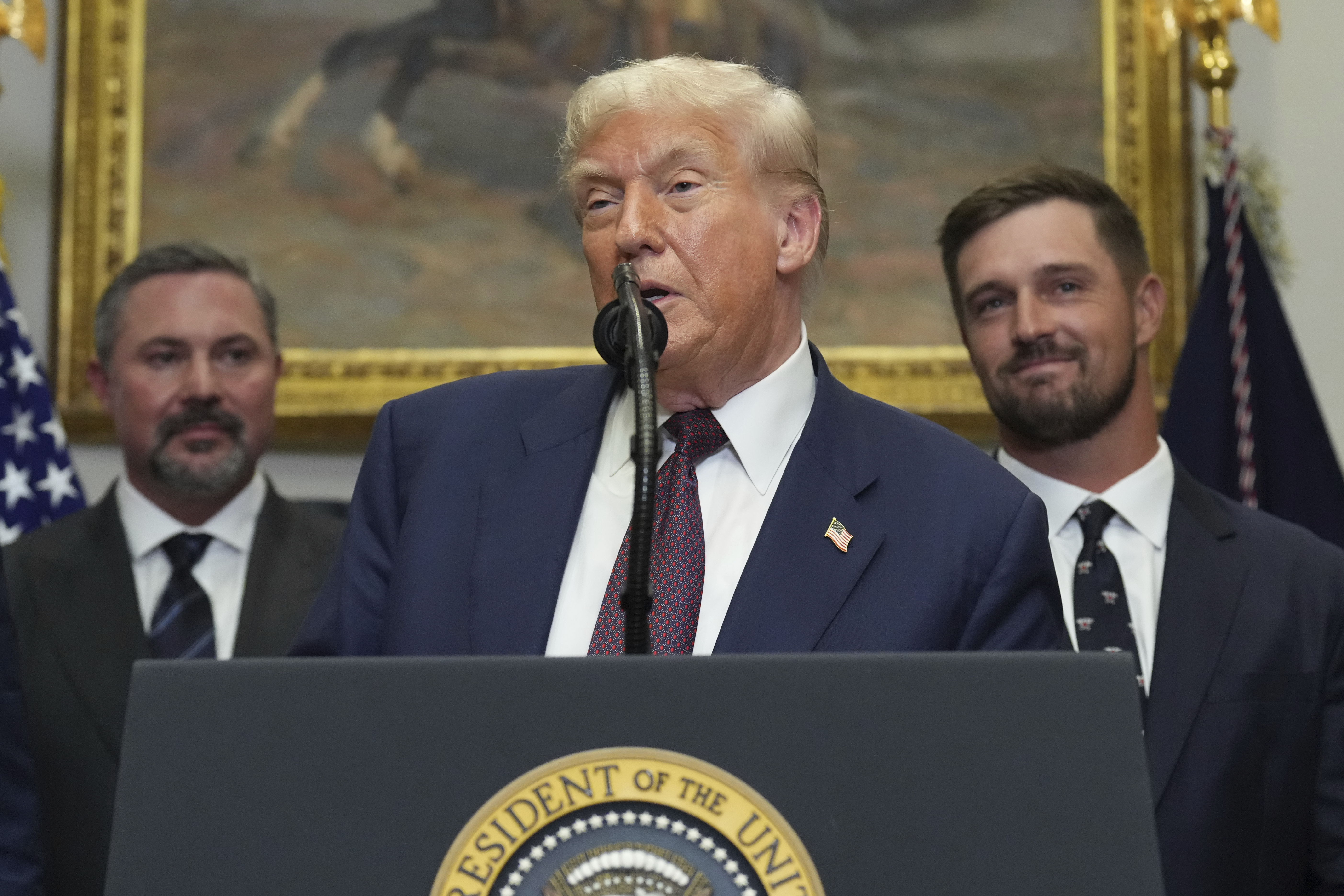 President Donald Trump speaks as Cody Campbell, left, and professional golfer Bryson DeChambeau listen during an event for the signing of an executive order restarting the Presidential Fitness Test in public schools, Thursday, July 31, 2025, in the Roosevelt Room of the White House in Washington. (AP Photo/Jacquelyn Martin)