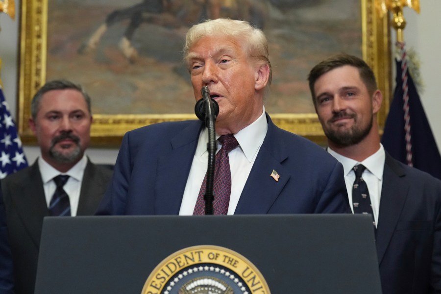 President Donald Trump speaks as Cody Campbell, left, and professional golfer Bryson DeChambeau listen during an event for the signing of an executive order restarting the Presidential Fitness Test in public schools, Thursday, July 31, 2025, in the Roosevelt Room of the White House in Washington. (AP Photo/Jacquelyn Martin)