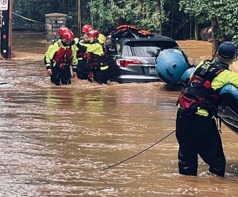 This photo provided by MontgomeryCo Fire shows the rescue of an 8-year old after flash flooding on Thursday, July 31, 2025. in Montgomery County, Md. (MontgomeryCo Fire via AP)