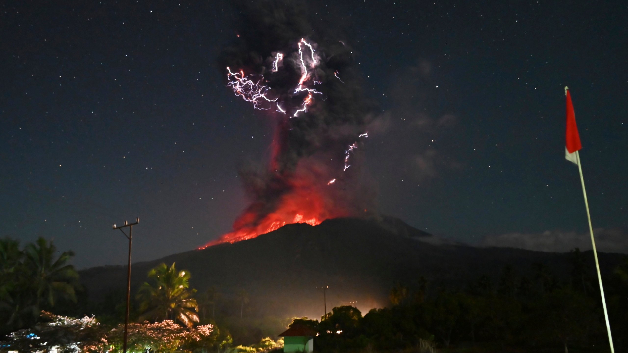 In this photo released by Geological Agency (Badan Geologi) of the Indonesia's Ministry of Energy and Mineral Resources, lightning strikes as Mount Lewotobi Laki-Laki spews volcanic material during an eruption in East Flores, Indonesia, Friday, August. 1, 2025. (Badan Geologi via AP)