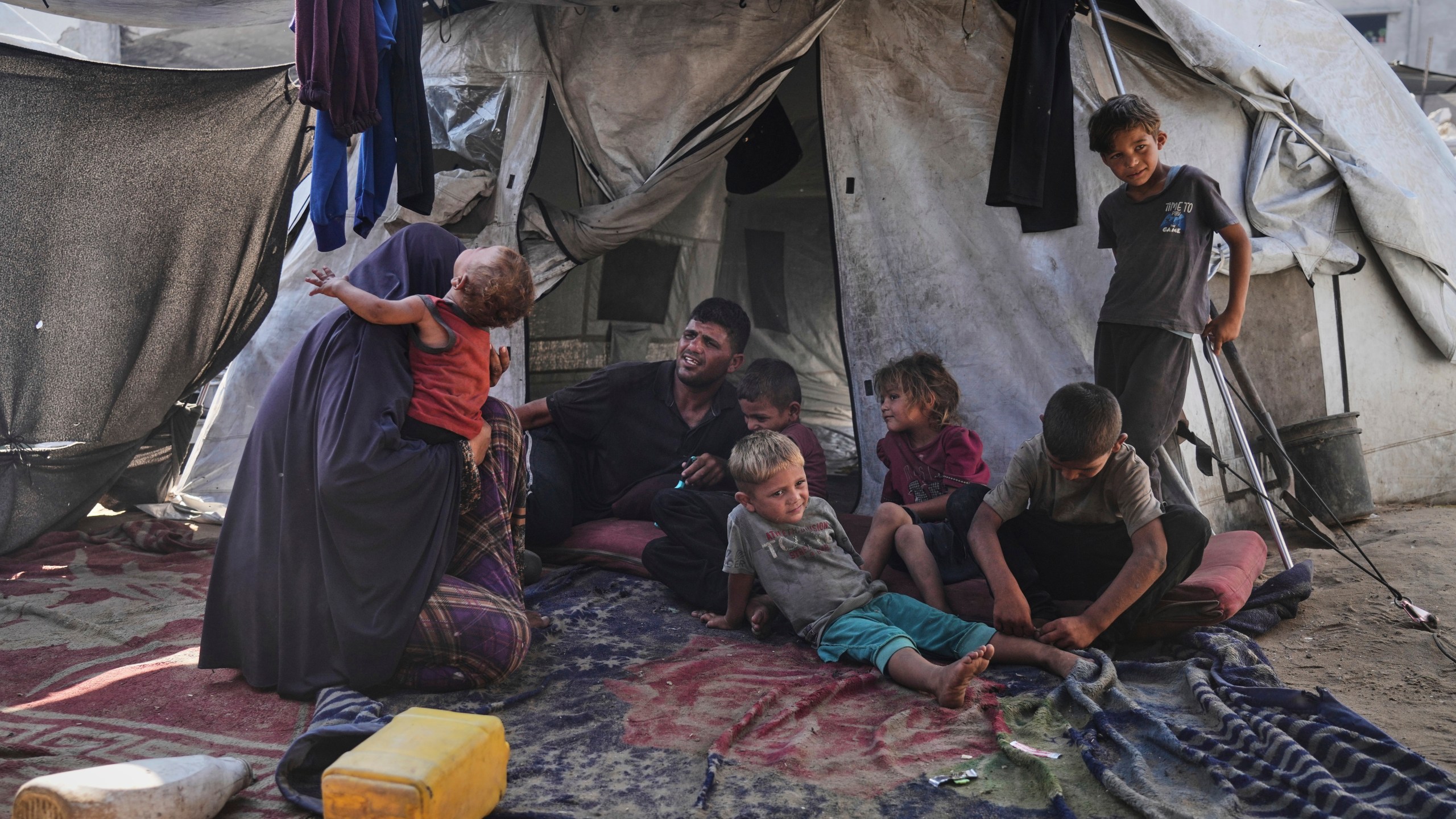 Abeer and Fadi Sobh gather in their tent with their children at a camp for displaced Palestinians in Gaza City, Thursday, July 24, 2025. (AP Photo/Jehad Alshrafi)