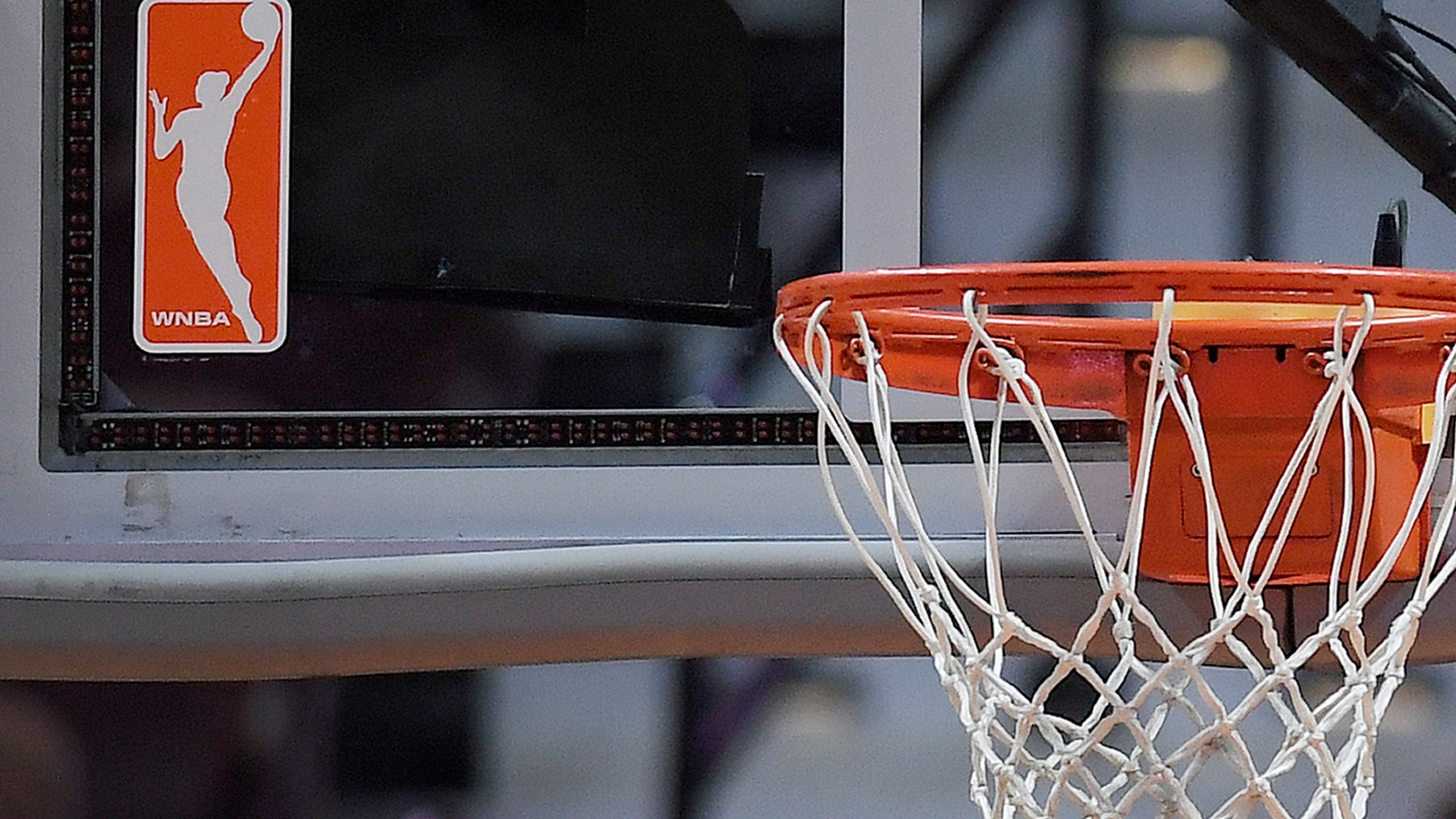 FILE - The WNBA logo is seen near a hoop before an WNBA basketball game at Mohegan Sun Arena, Tuesday, May 14, 2019, in Uncasville, Conn. (AP Photo/Jessica Hill, File)
