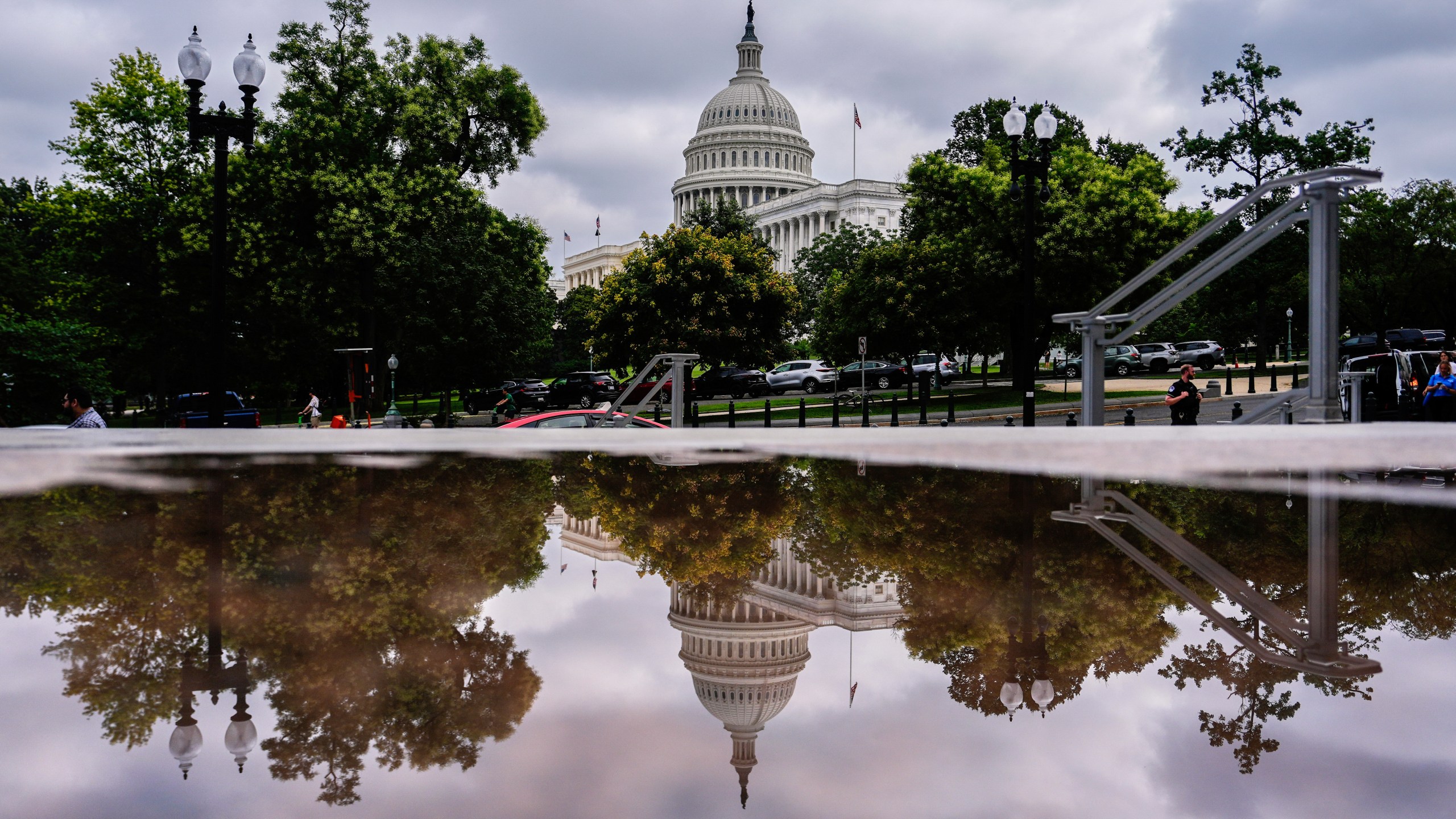 The U.S. Capitol is reflected in a puddle outside of the Rayburn House Office Building, Wednesday, July 16, 2025, on Capitol Hill in Washington. (AP Photo/Julia Demaree Nikhinson)