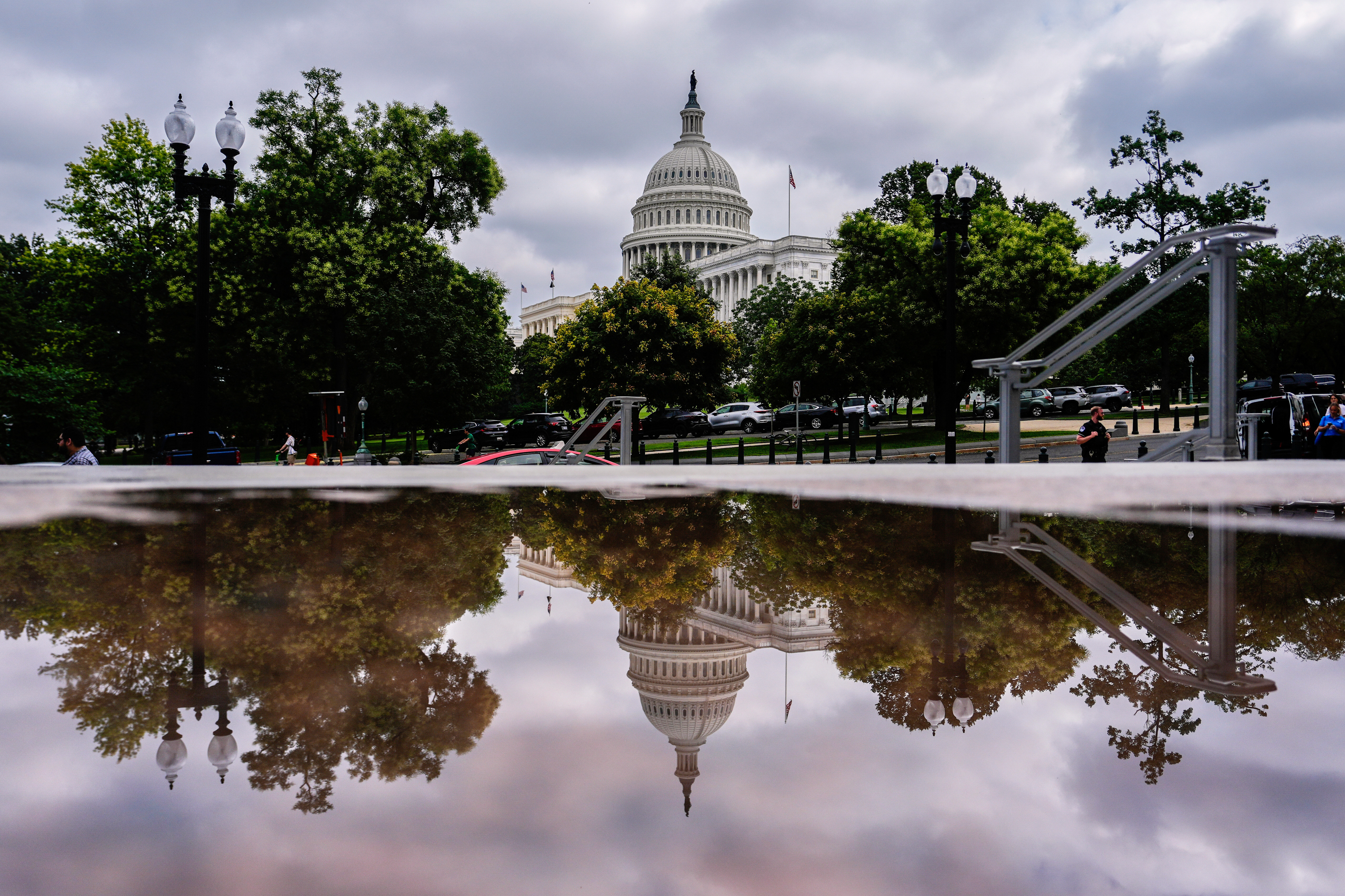 The U.S. Capitol is reflected in a puddle outside of the Rayburn House Office Building, Wednesday, July 16, 2025, on Capitol Hill in Washington. (AP Photo/Julia Demaree Nikhinson)