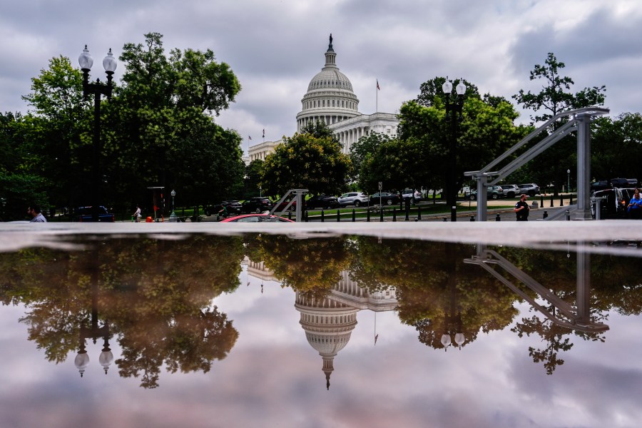 The U.S. Capitol is reflected in a puddle outside of the Rayburn House Office Building, Wednesday, July 16, 2025, on Capitol Hill in Washington. (AP Photo/Julia Demaree Nikhinson)