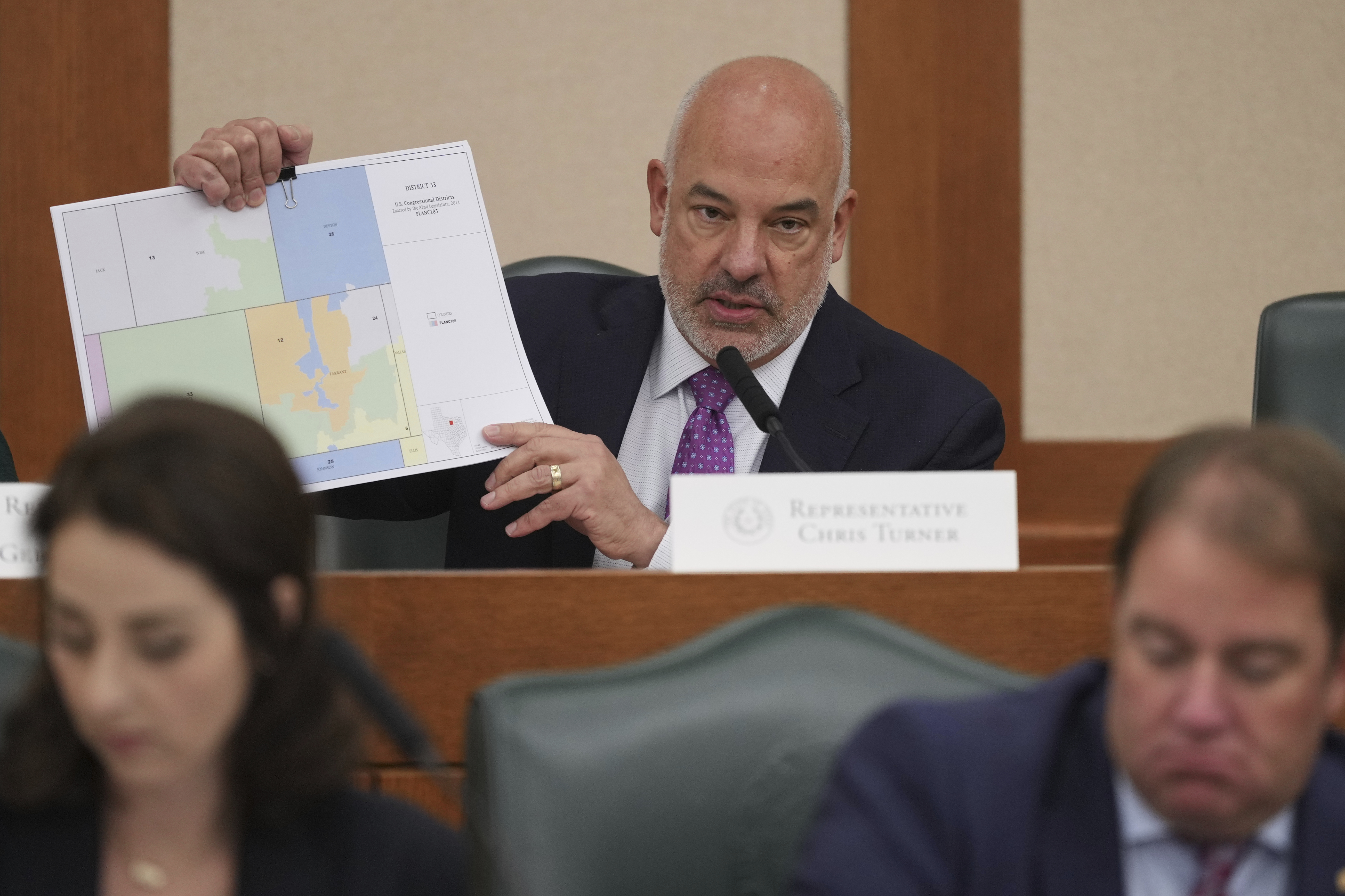 Texas state Rep Chris Turner holds a map as he asks questions during a public hearing on congressional redistricting in Austin, Texas, Friday, Aug. 1, 2025. (AP Photo/Eric Gay)