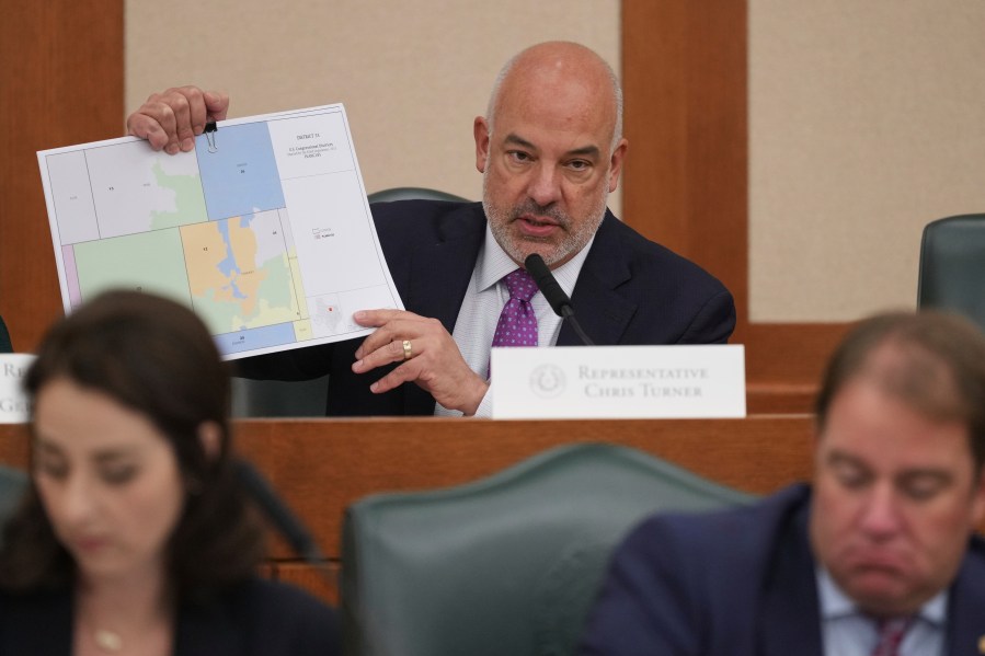 Texas state Rep Chris Turner holds a map as he asks questions during a public hearing on congressional redistricting in Austin, Texas, Friday, Aug. 1, 2025. (AP Photo/Eric Gay)