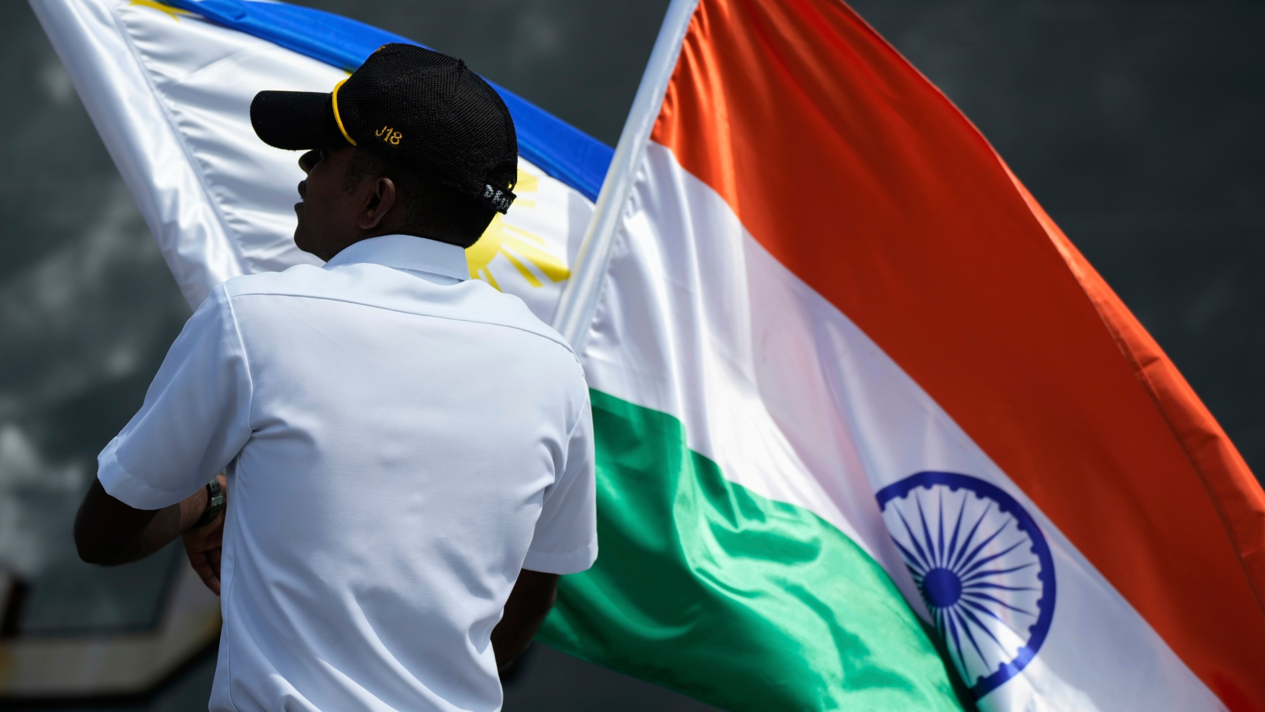 A crew arranges the Philippine and Indian national flags as Indian Navy survey ship INS Sandhayak docks at Manila's port, Philippines, on Friday, Aug. 1, 2025. (AP Photo/Aaron Favila)