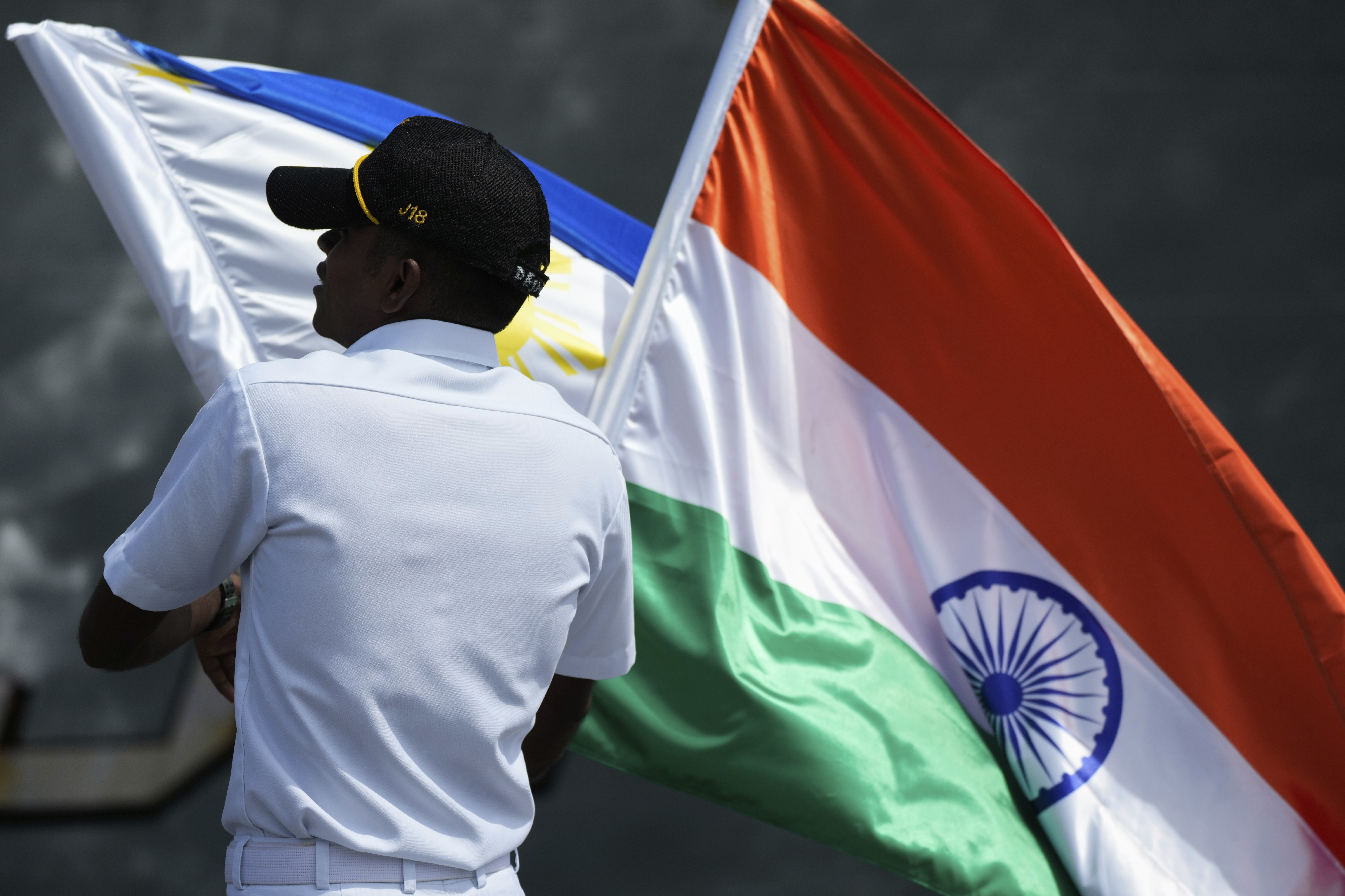 A crew arranges the Philippine and Indian national flags as Indian Navy survey ship INS Sandhayak docks at Manila's port, Philippines, on Friday, Aug. 1, 2025. (AP Photo/Aaron Favila)