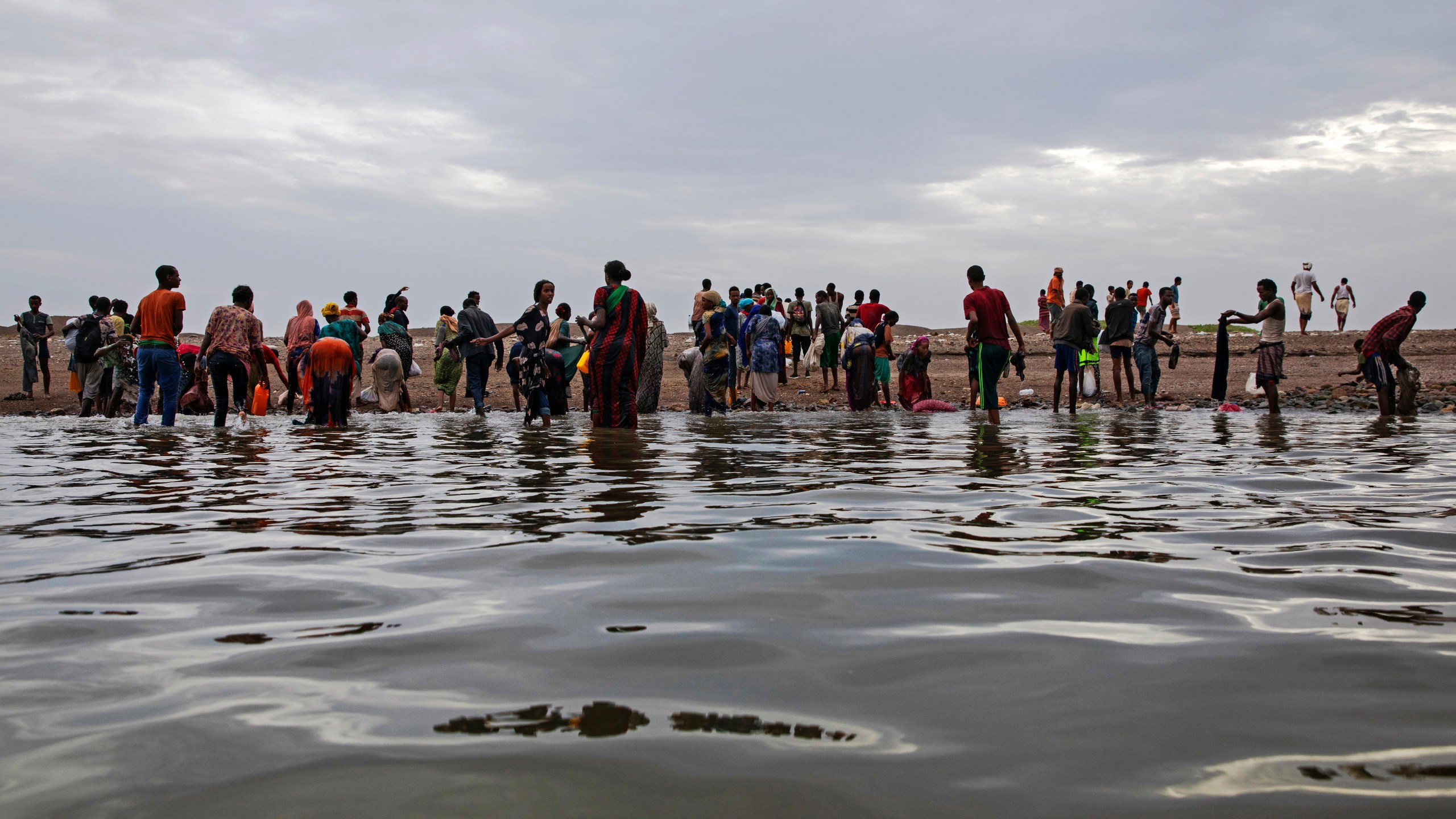 FILE - Ethiopian migrants walk on the shores of Ras al-Ara, Lahj, Yemen, after disembarking from a boat, July 26, 2019. (AP Photo/Nariman El-Mofty, File)