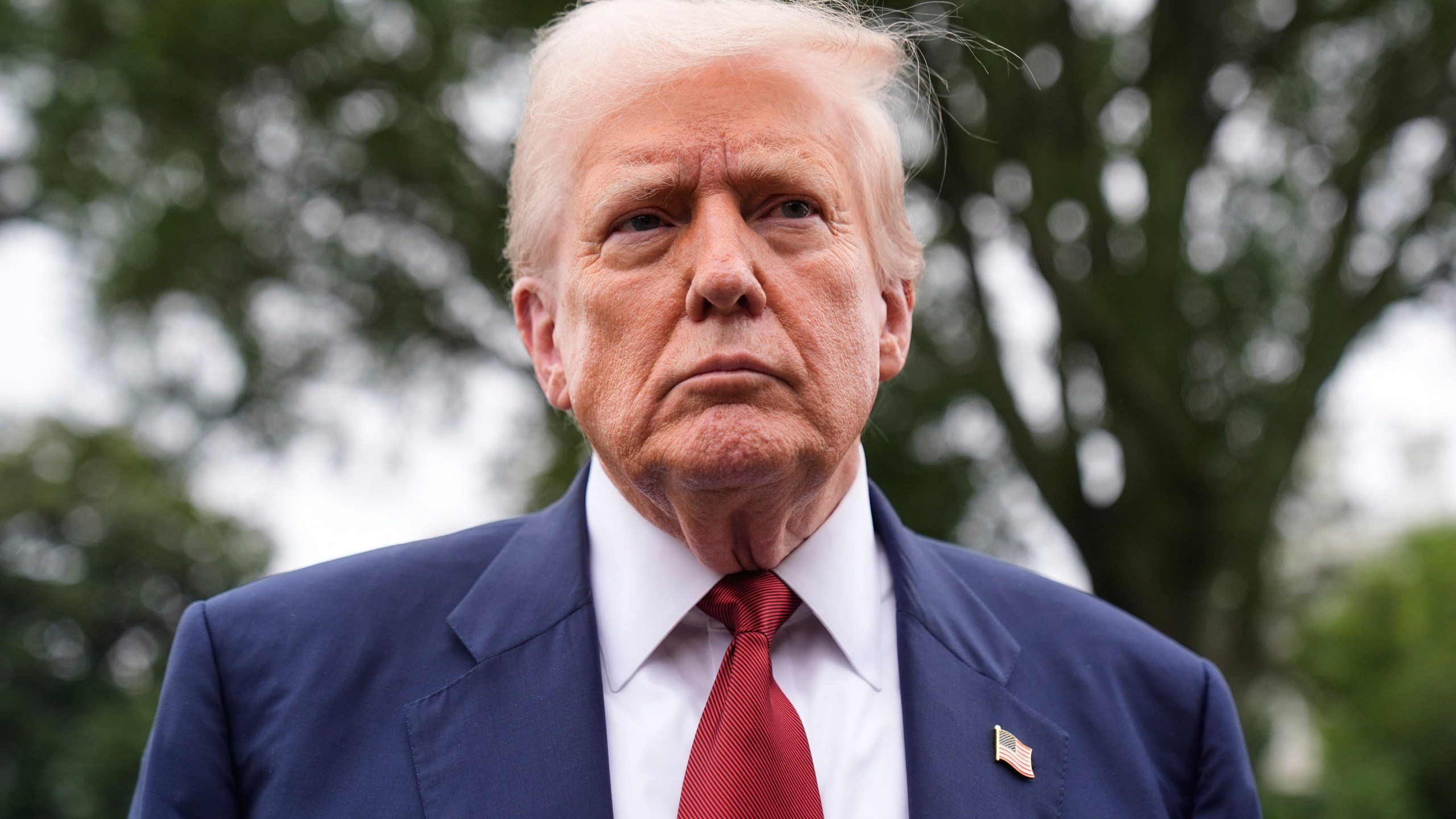 President Donald Trump talks to reporters on the South Lawn of the White House before he boards Marine One en route to Joint Base Andrews, Md., Friday, Aug. 1, 2025, in Washington. (AP Photo/Mark Schiefelbein)