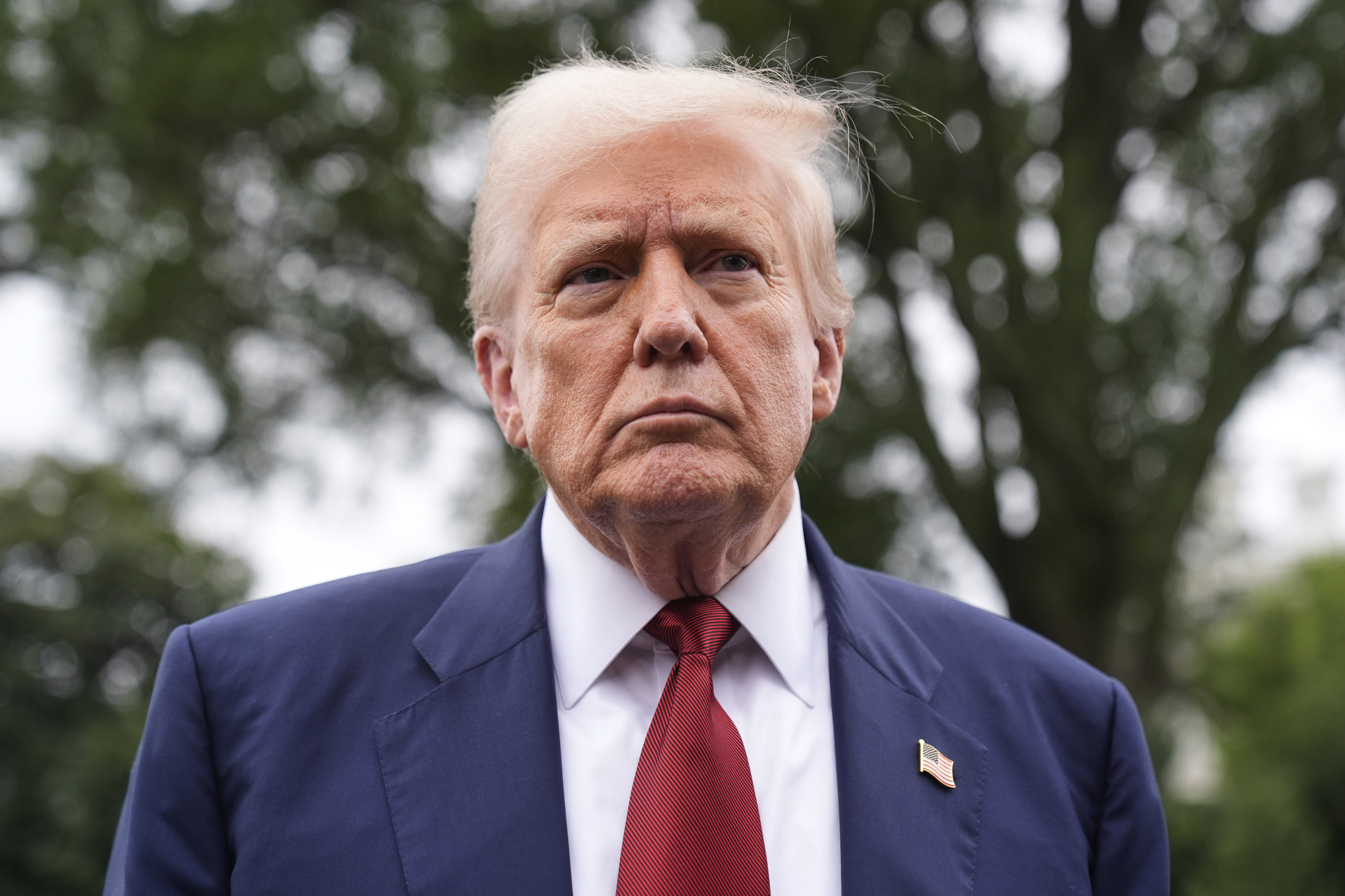 President Donald Trump talks to reporters on the South Lawn of the White House before he boards Marine One en route to Joint Base Andrews, Md., Friday, Aug. 1, 2025, in Washington. (AP Photo/Mark Schiefelbein)