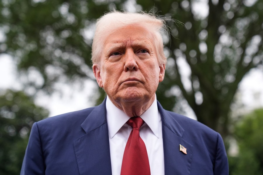 President Donald Trump talks to reporters on the South Lawn of the White House before he boards Marine One en route to Joint Base Andrews, Md., Friday, Aug. 1, 2025, in Washington. (AP Photo/Mark Schiefelbein)