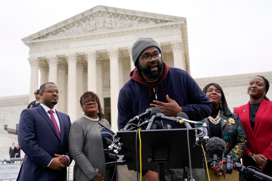 FILE - Evan Milligan, center, plaintiff in Merrill v. Milligan, an Alabama redistricting case, speaks with reporters following oral arguments at the Supreme Court in Washington, Oct. 4, 2022. (AP Photo/Patrick Semansky, File)