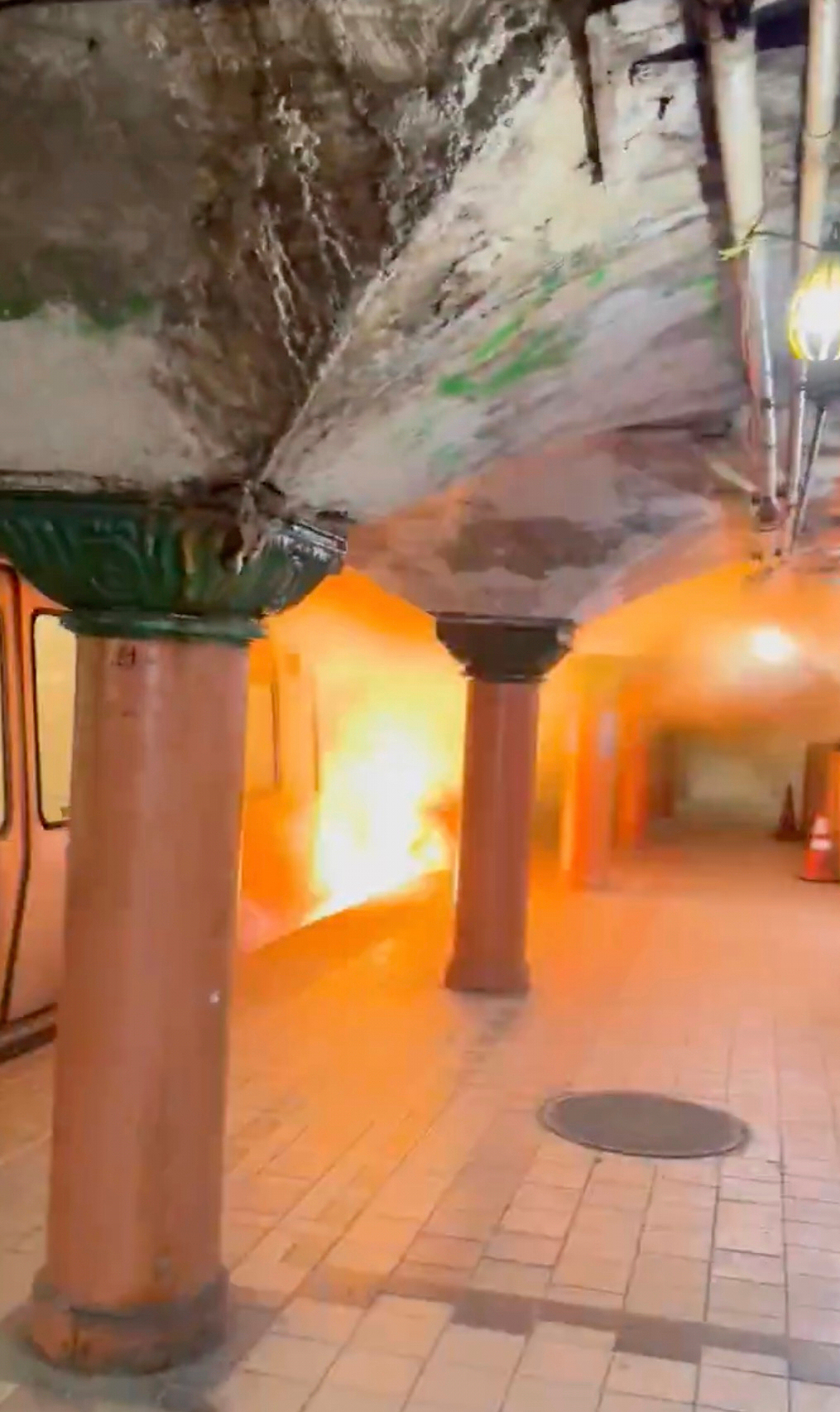 This image provided by Joseph Nikhil Reddy shows flames rising nearly to the top of a Port Authority Trans-Hudson (PATH) train car at the Newport station in Jersey City, N.J., Monday, Aug. 4, 2025. (Joseph Nikhil Reddy via AP)