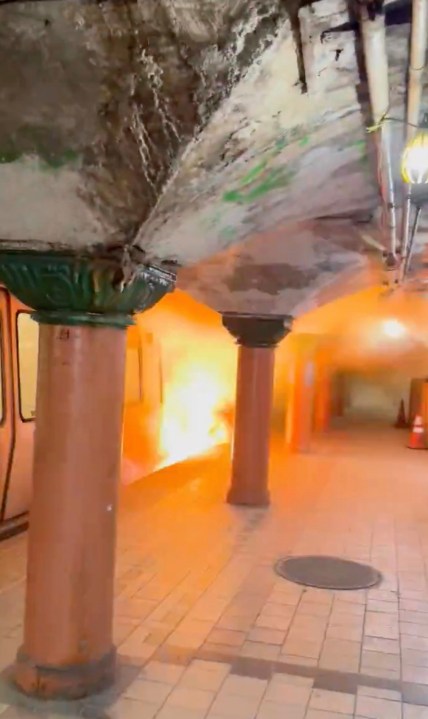 This image provided by Joseph Nikhil Reddy shows flames rising nearly to the top of a Port Authority Trans-Hudson (PATH) train car at the Newport station in Jersey City, N.J., Monday, Aug. 4, 2025. (Joseph Nikhil Reddy via AP)