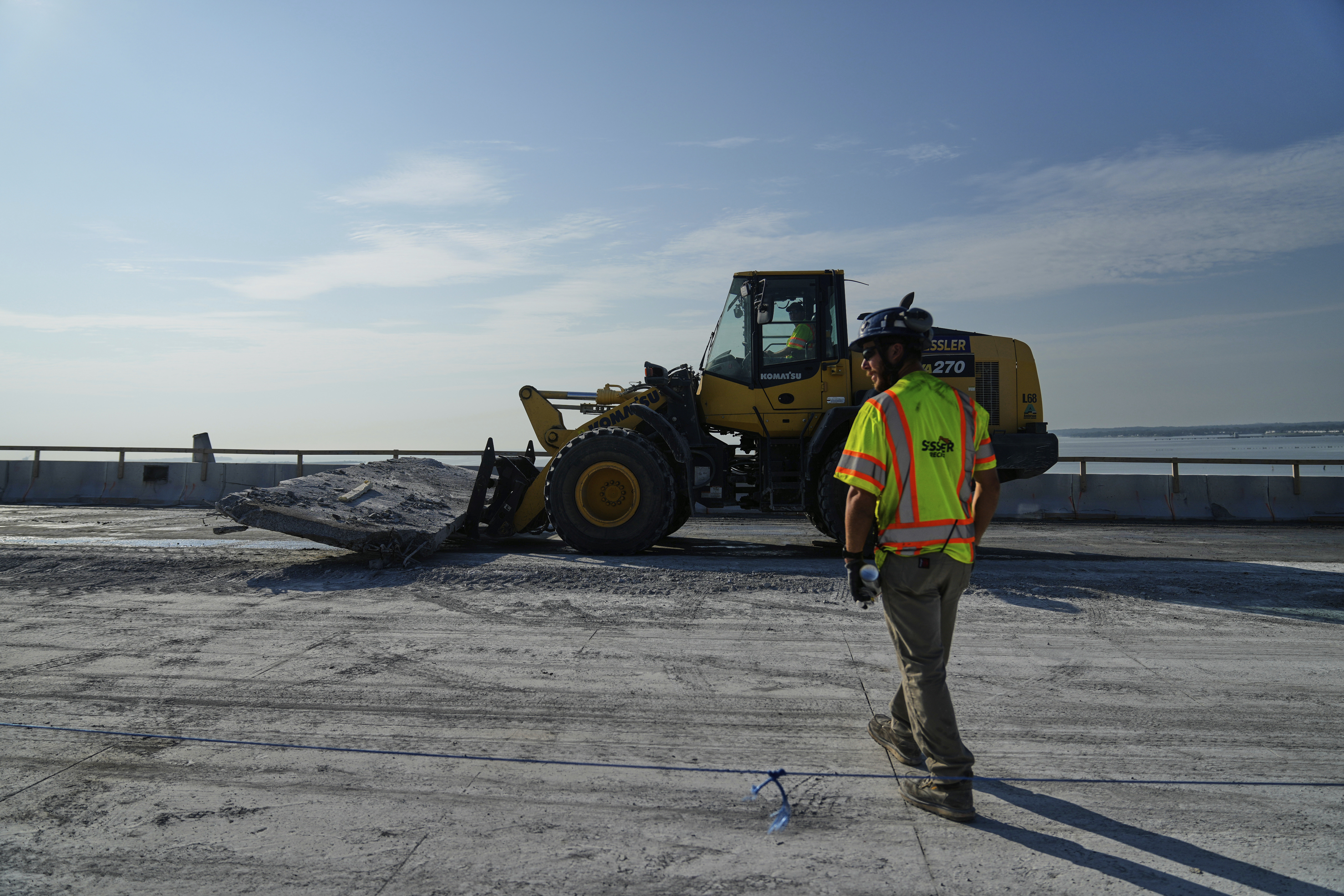 A demolition crew removes a slab of concrete from the remaining portions of the Francis Scott Key Bridge, Wednesday, July 30, 2025, in Baltimore. (AP Photo/Stephanie Scarbrough)