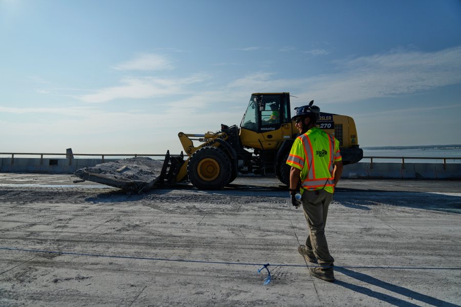 A demolition crew removes a slab of concrete from the remaining portions of the Francis Scott Key Bridge, Wednesday, July 30, 2025, in Baltimore. (AP Photo/Stephanie Scarbrough)