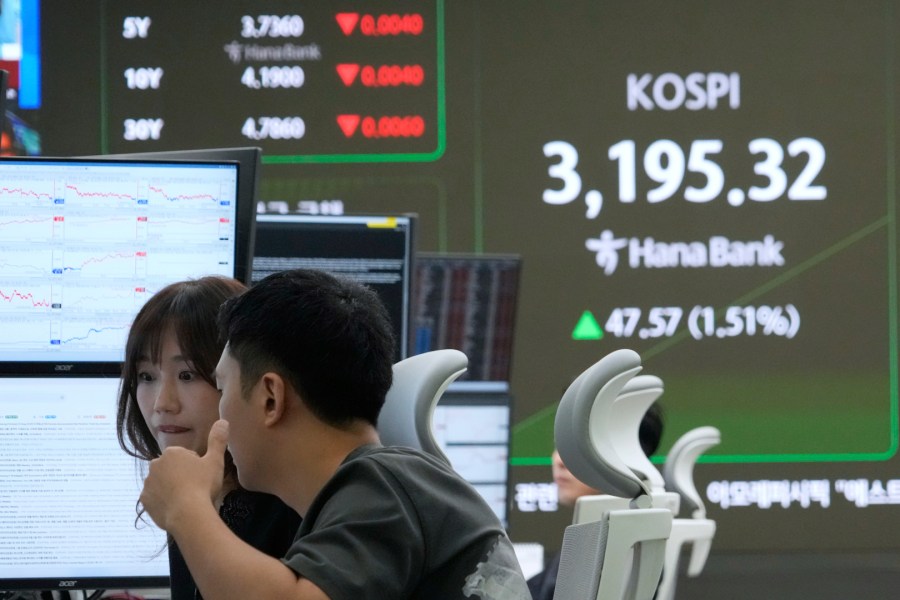 Currency traders watch monitors near a screen showing the Korea Composite Stock Price Index (KOSPI) at the foreign exchange dealing room of the Hana Bank headquarters in Seoul, South Korea, Tuesday, Aug. 5, 2025. (AP Photo/Ahn Young-joon)