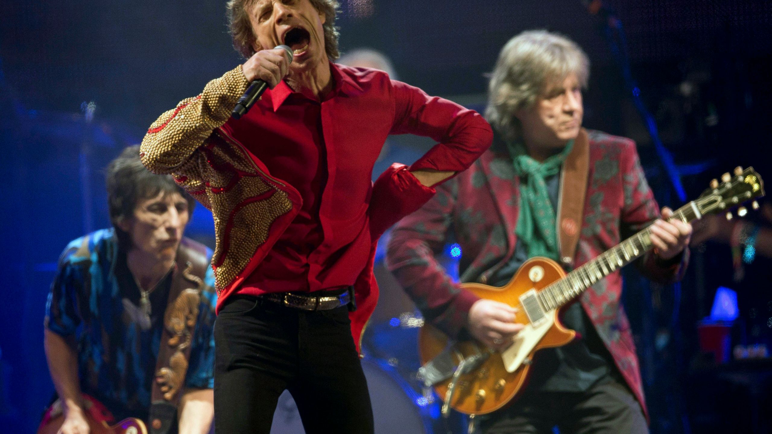 FILE - Mick Jagger, center, Ronnie Wood, left, and Mick Taylor, of British rock band The Rolling Stones, perform on the Pyramid main stage at Glastonbury, England, June 29, 2013. (Joel Ryan/Invision/AP, File)