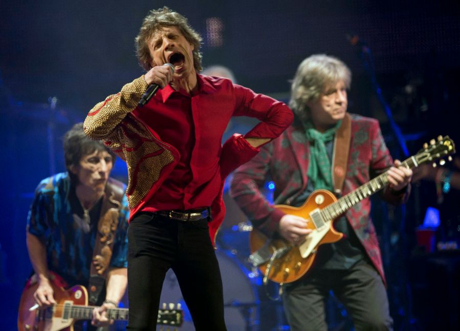 FILE - Mick Jagger, center, Ronnie Wood, left, and Mick Taylor, of British rock band The Rolling Stones, perform on the Pyramid main stage at Glastonbury, England, June 29, 2013. (Joel Ryan/Invision/AP, File)