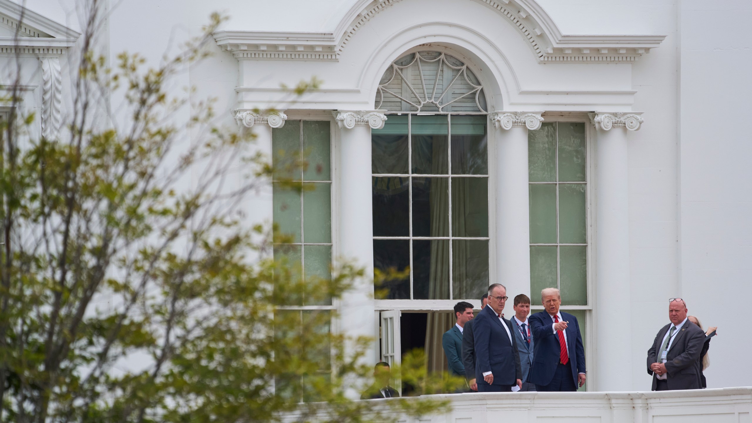 President Donald Trump, second from the right, with architect James McCrery, center, surveys the grounds from the roof above the Colonnade that goes to the West Wing of the White House, Tuesday, Aug. 5, 2025, in Washington. (AP Photo/Evan Vucci)
