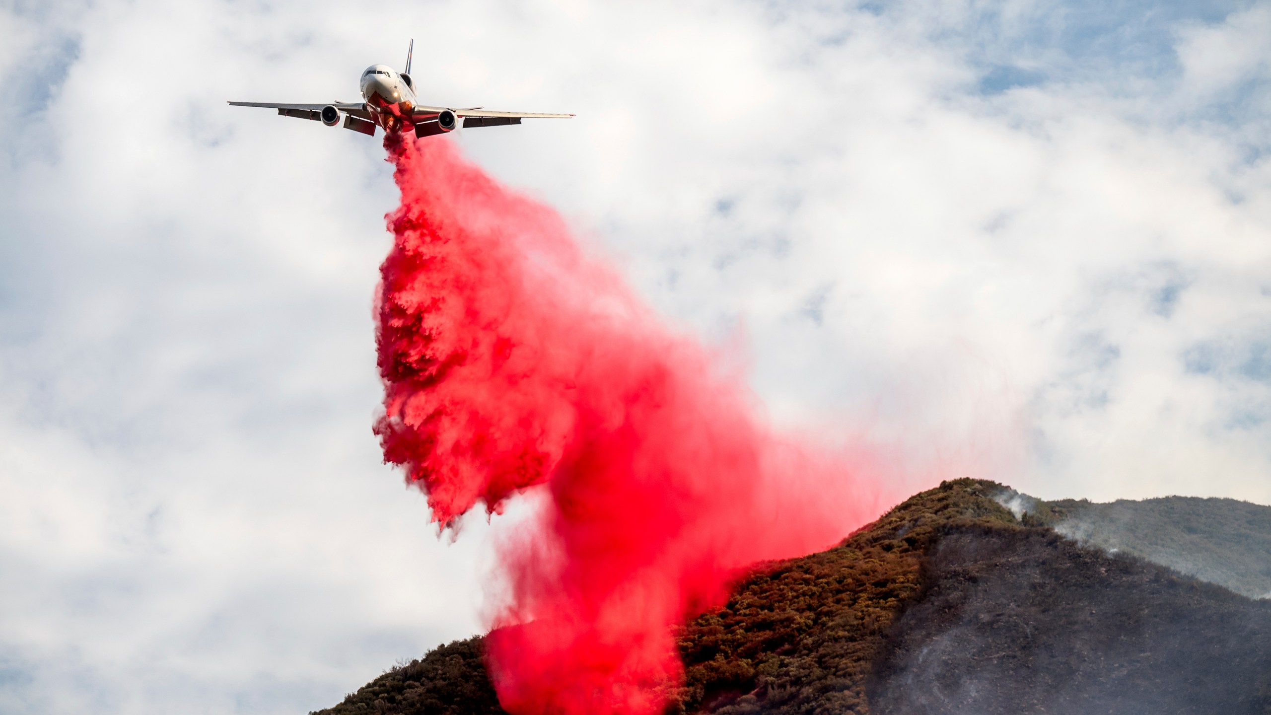 An air tanker drops retardant on the Gifford Fire burning on Monday, Aug. 4, 2025, in Los Padres National Forest, Calif. (AP Photo/Noah Berger)
