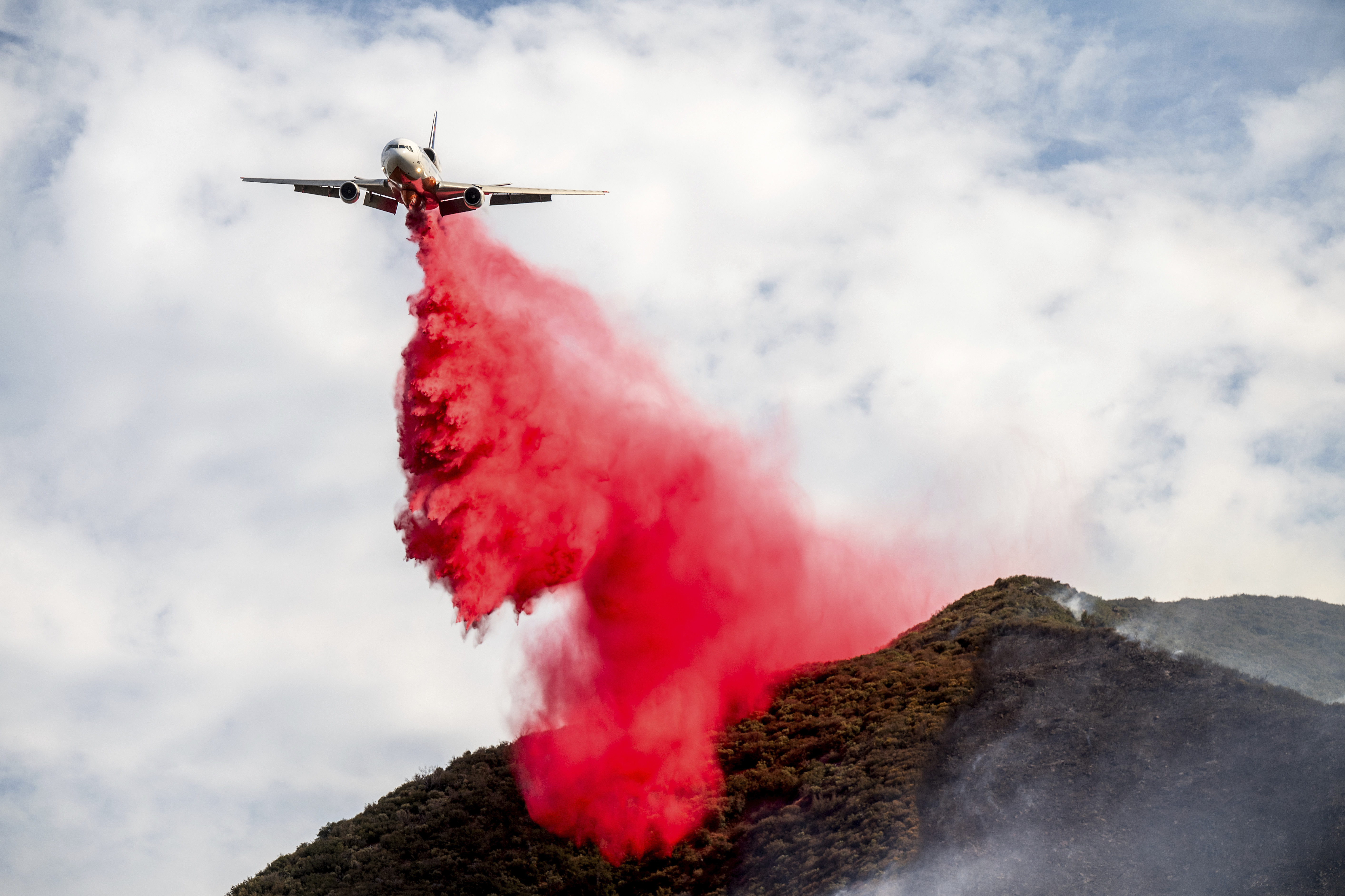 An air tanker drops retardant on the Gifford Fire burning on Monday, Aug. 4, 2025, in Los Padres National Forest, Calif. (AP Photo/Noah Berger)